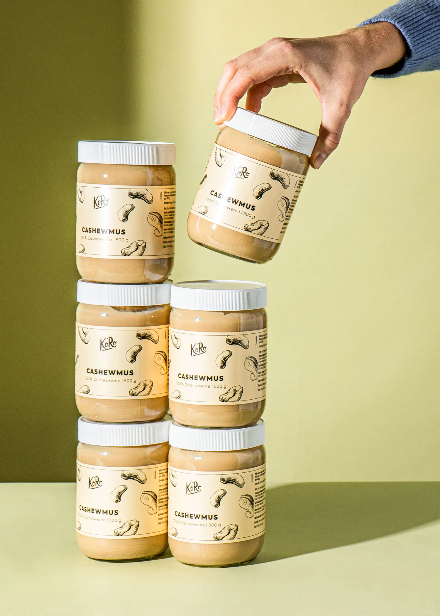 a person is holding a jar of cashewmus in their hand