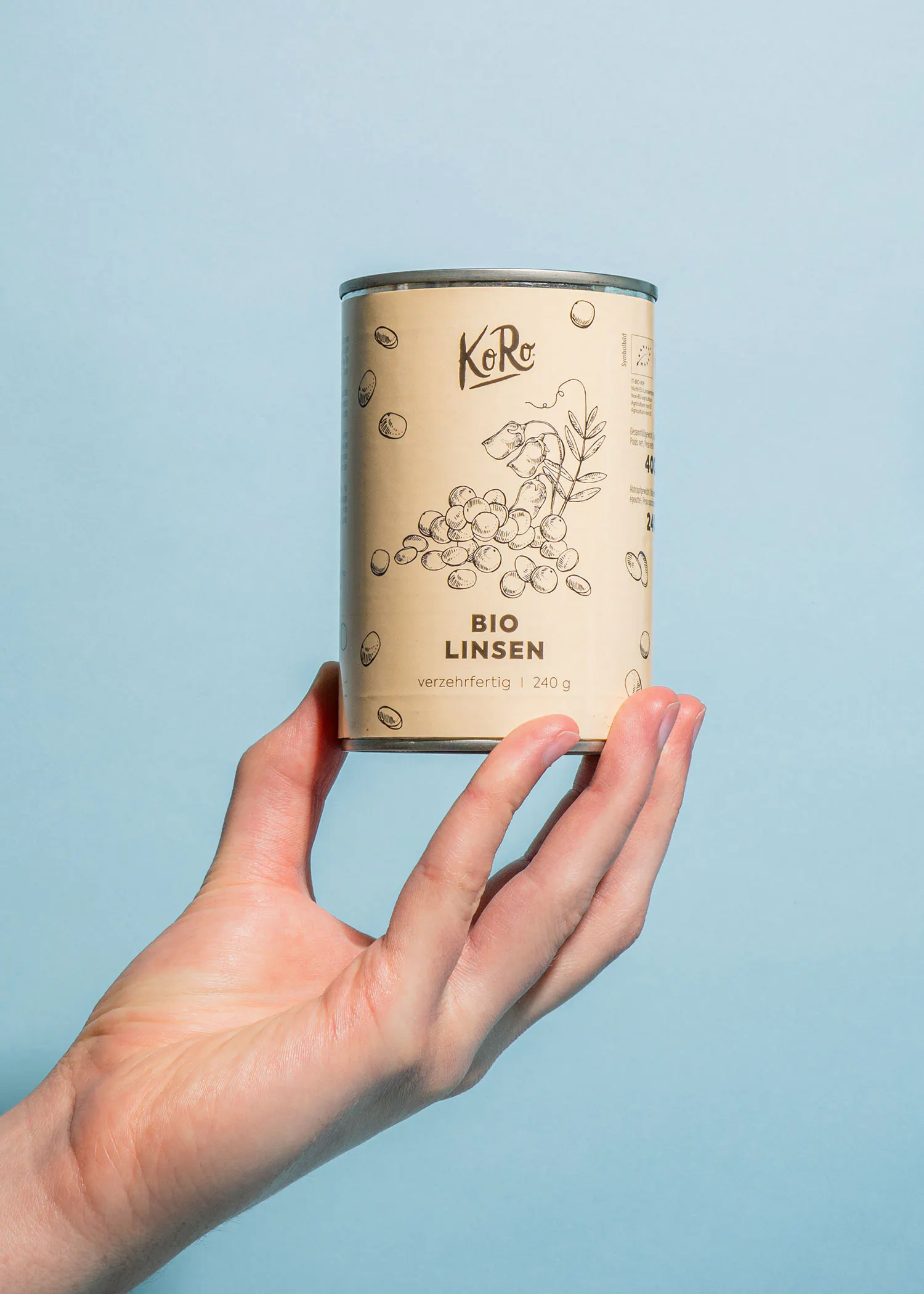 une main tient une boîte de bio linsen