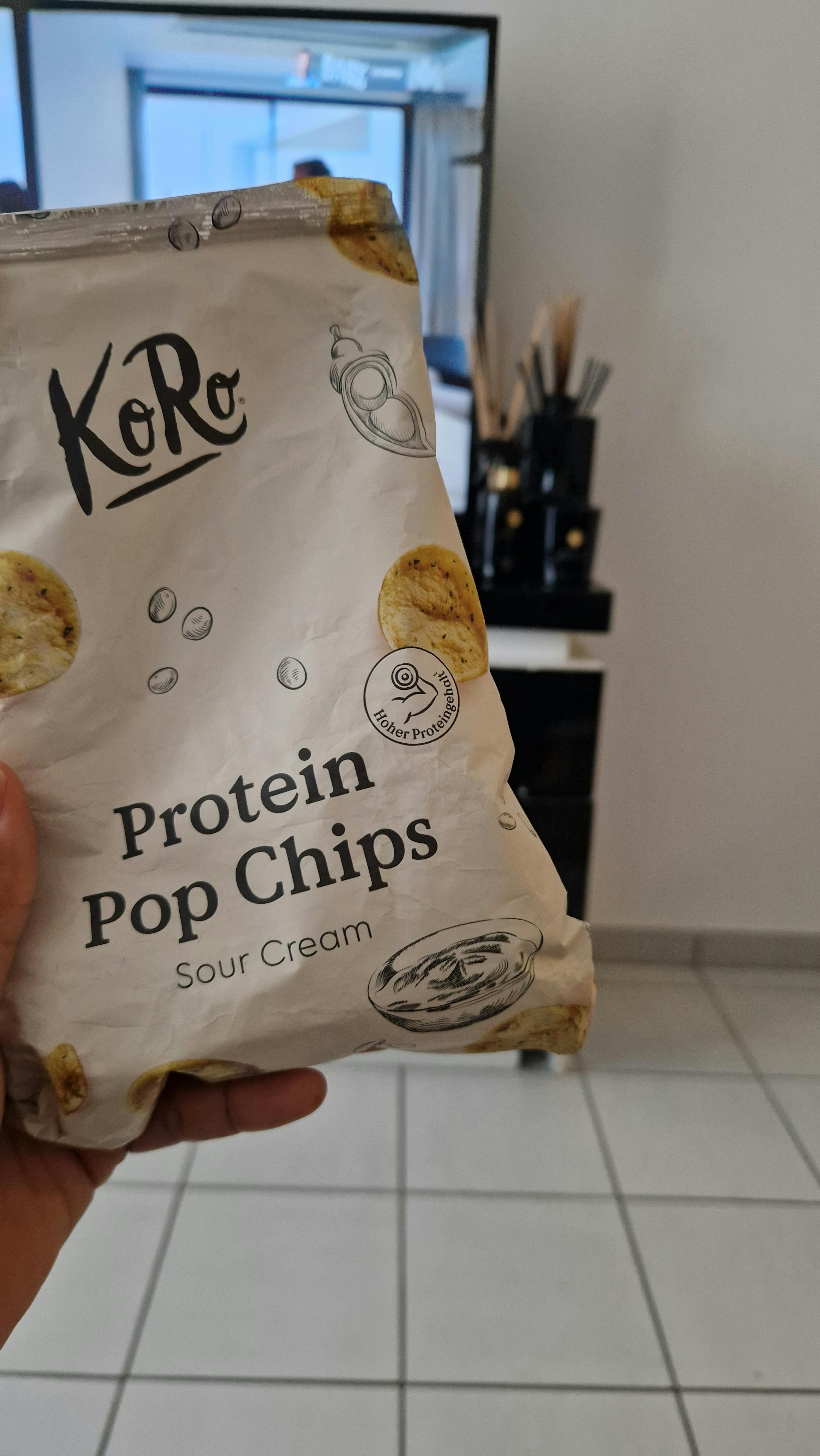 eine Person hält eine Tüte protein-Pop-Chips sour cream