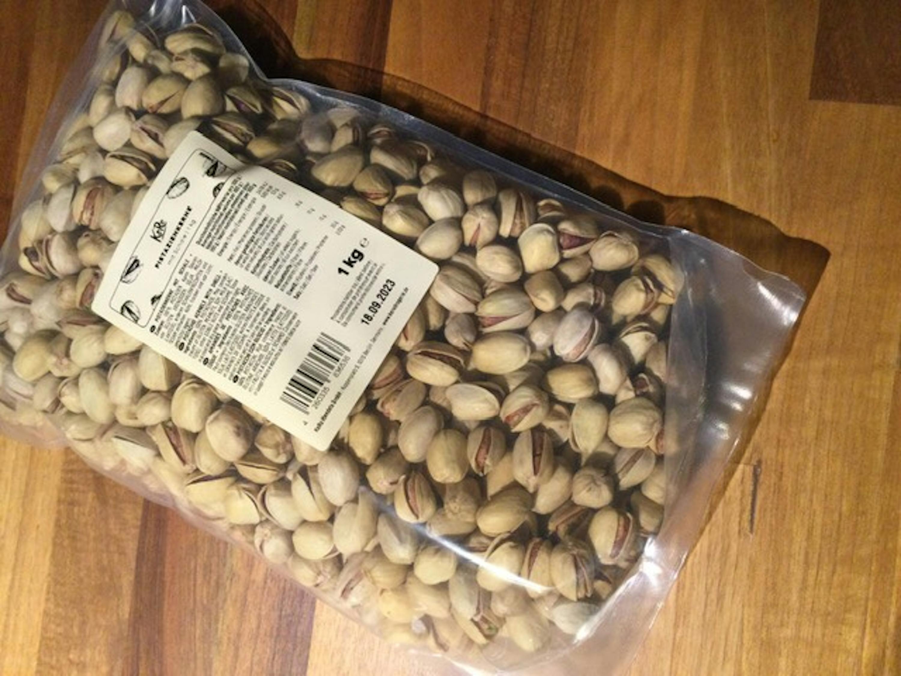 a bag of pistachios is on a wooden table