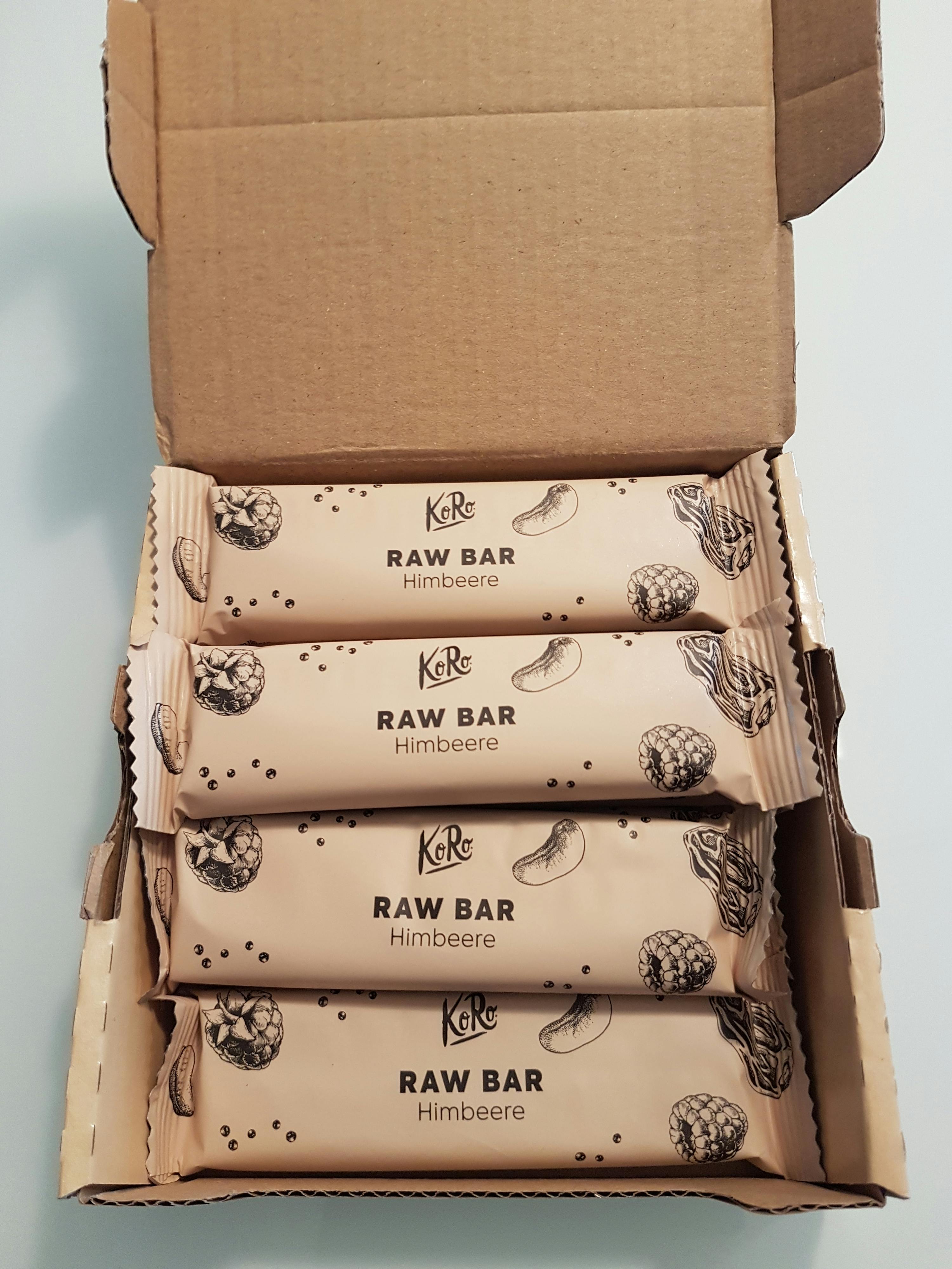 una scatola di barrette raw è aperta su un tavolo bianco