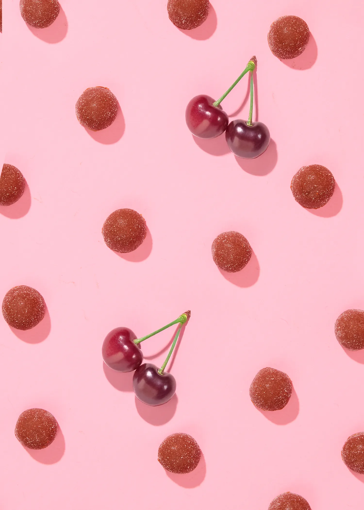 a pink background with cherries and gummy cherries