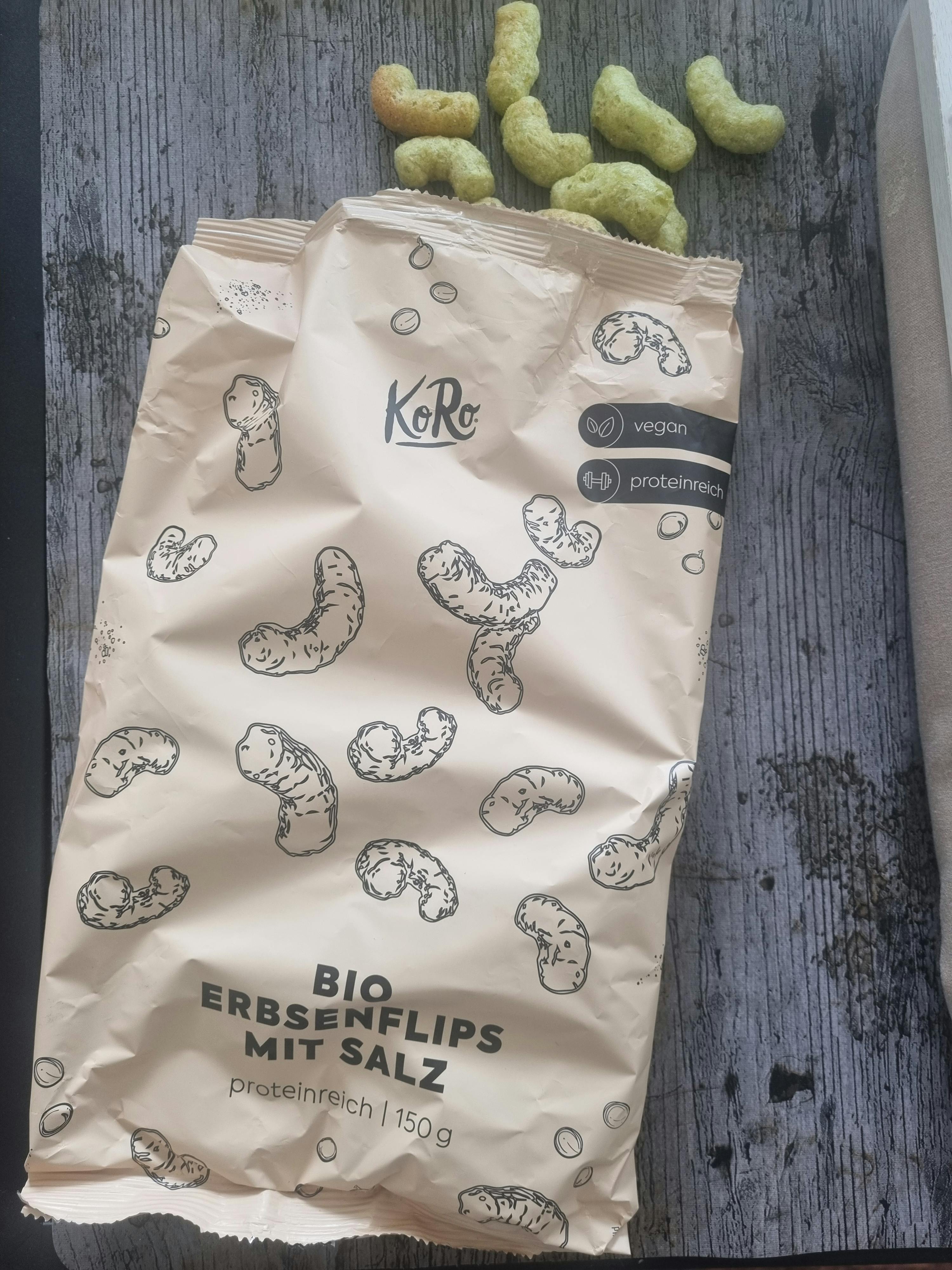 eine Tüte erbsenflips mit Salz liegt auf einem Holztisch