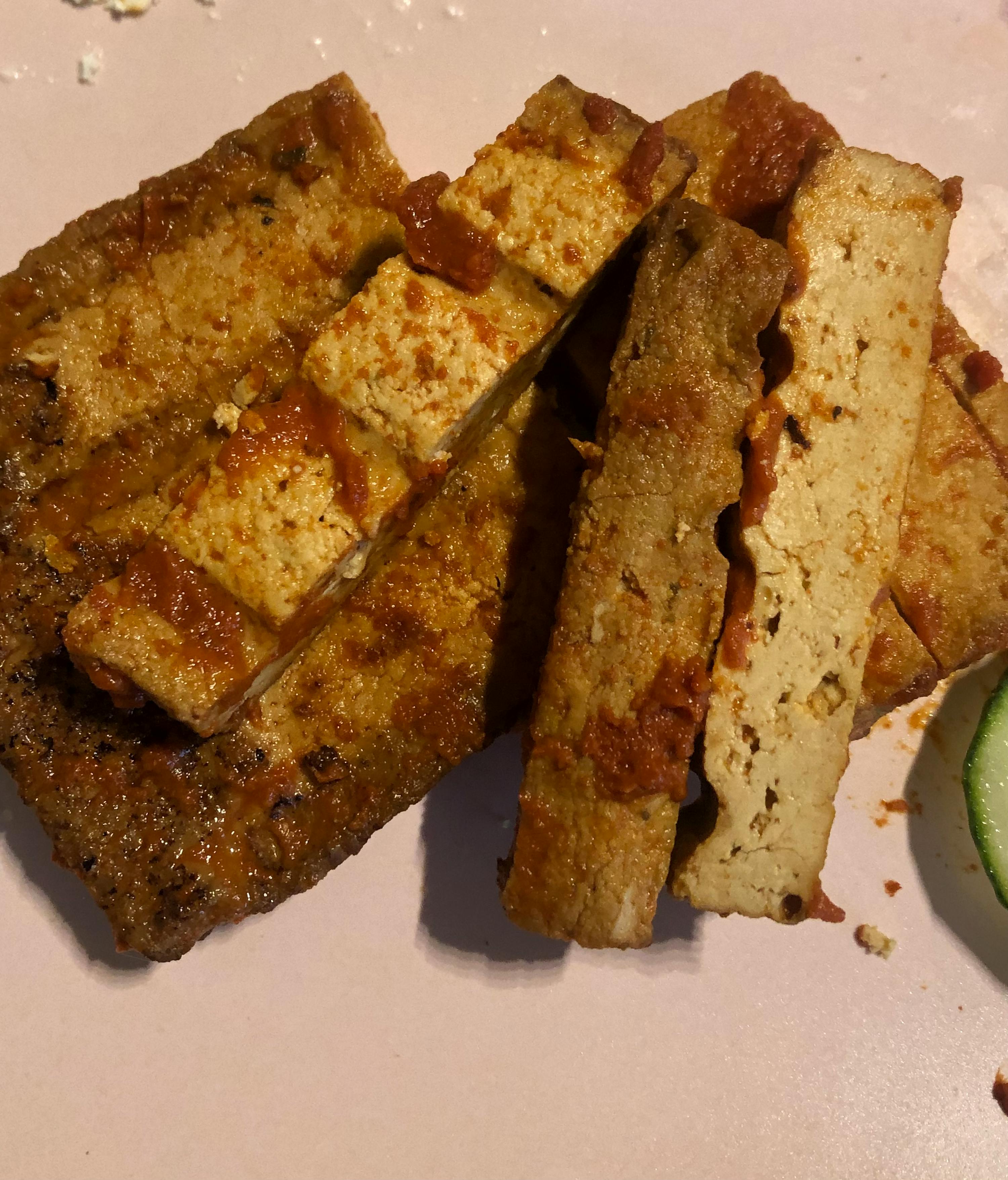 eine Nahaufnahme von einem Stück Tofu mit Tomatensauce