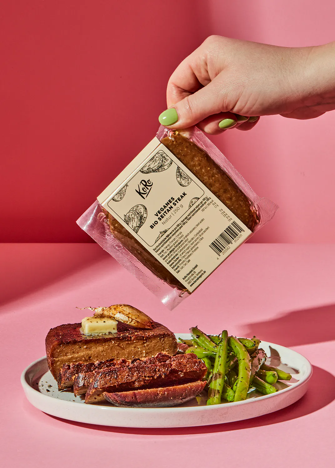a person is holding a bag of veggie steak over a plate of food