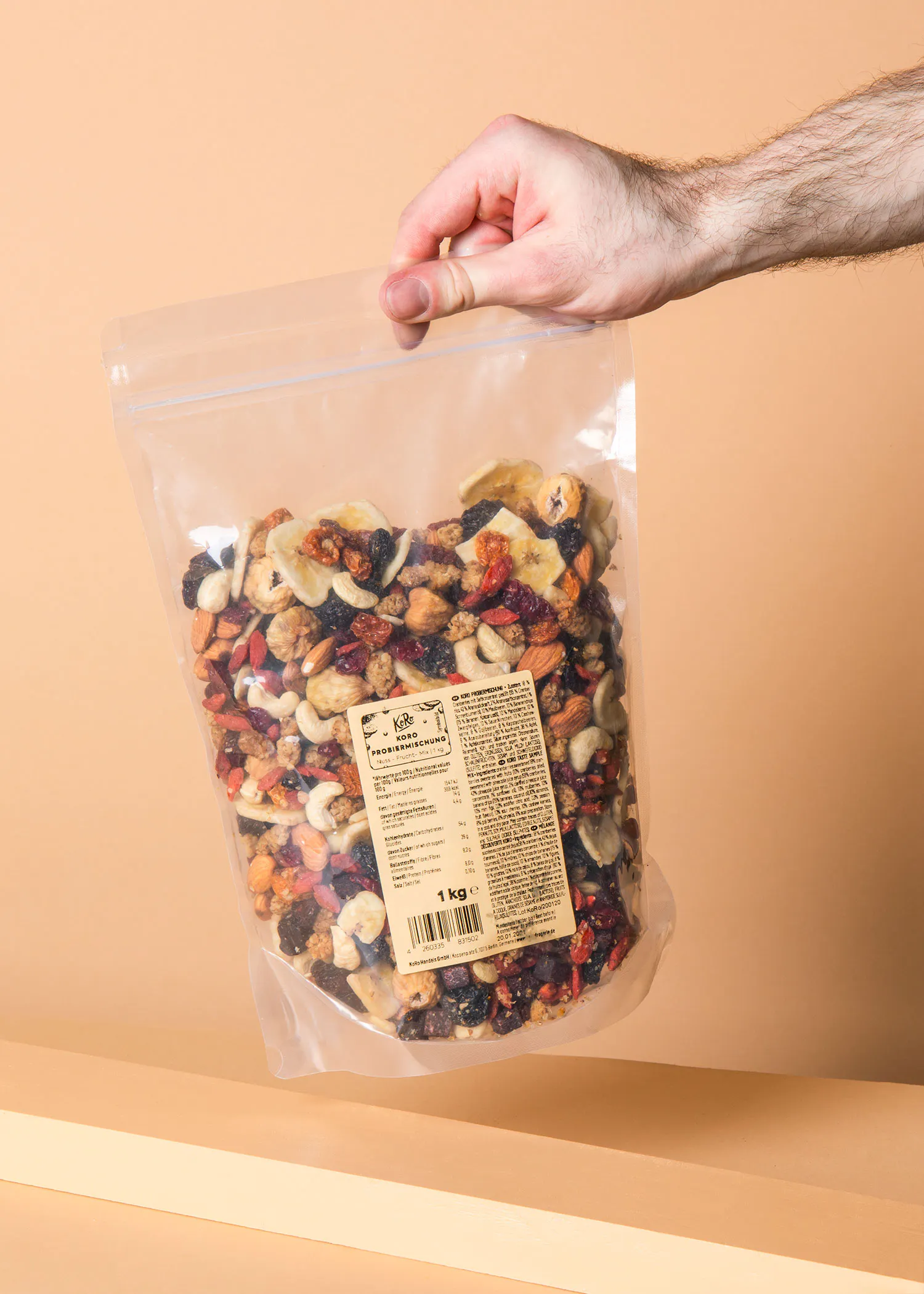 une main tient un sac de noix et de fruits séchés