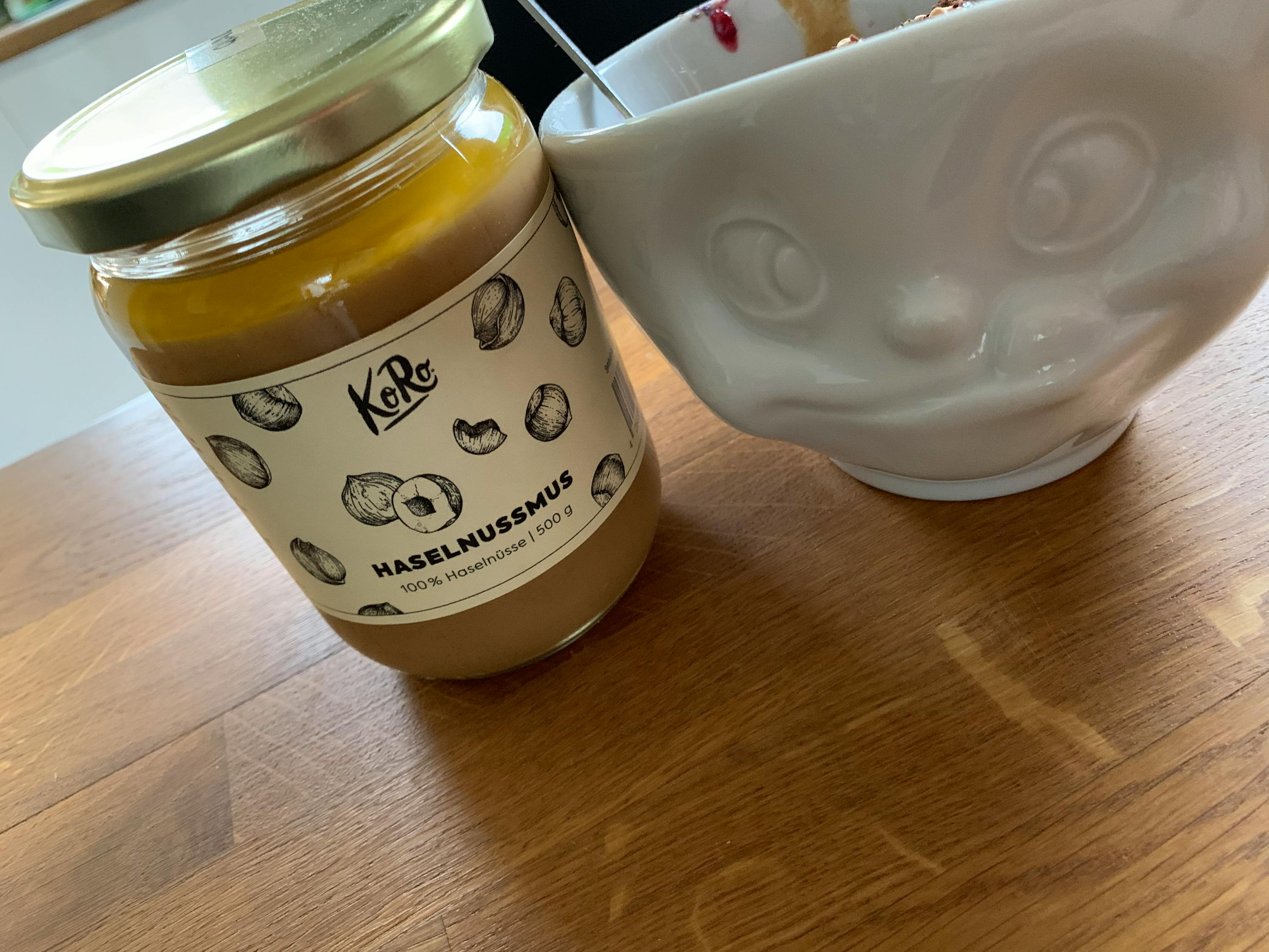 un barattolo di hazelnussmus è su un tavolo accanto a una ciotola