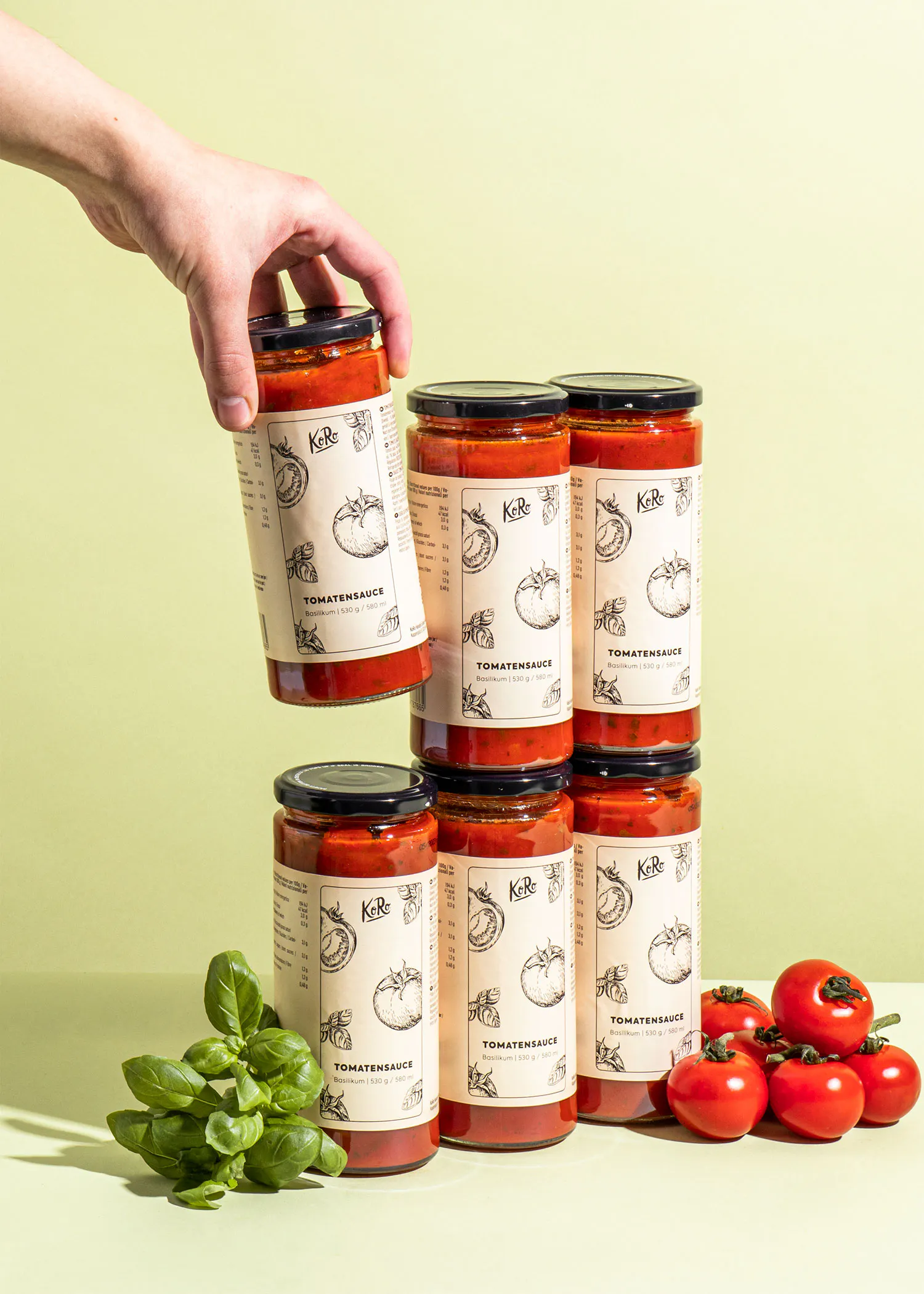 Eine Person hält ein Glas Tomatensauce in der Hand