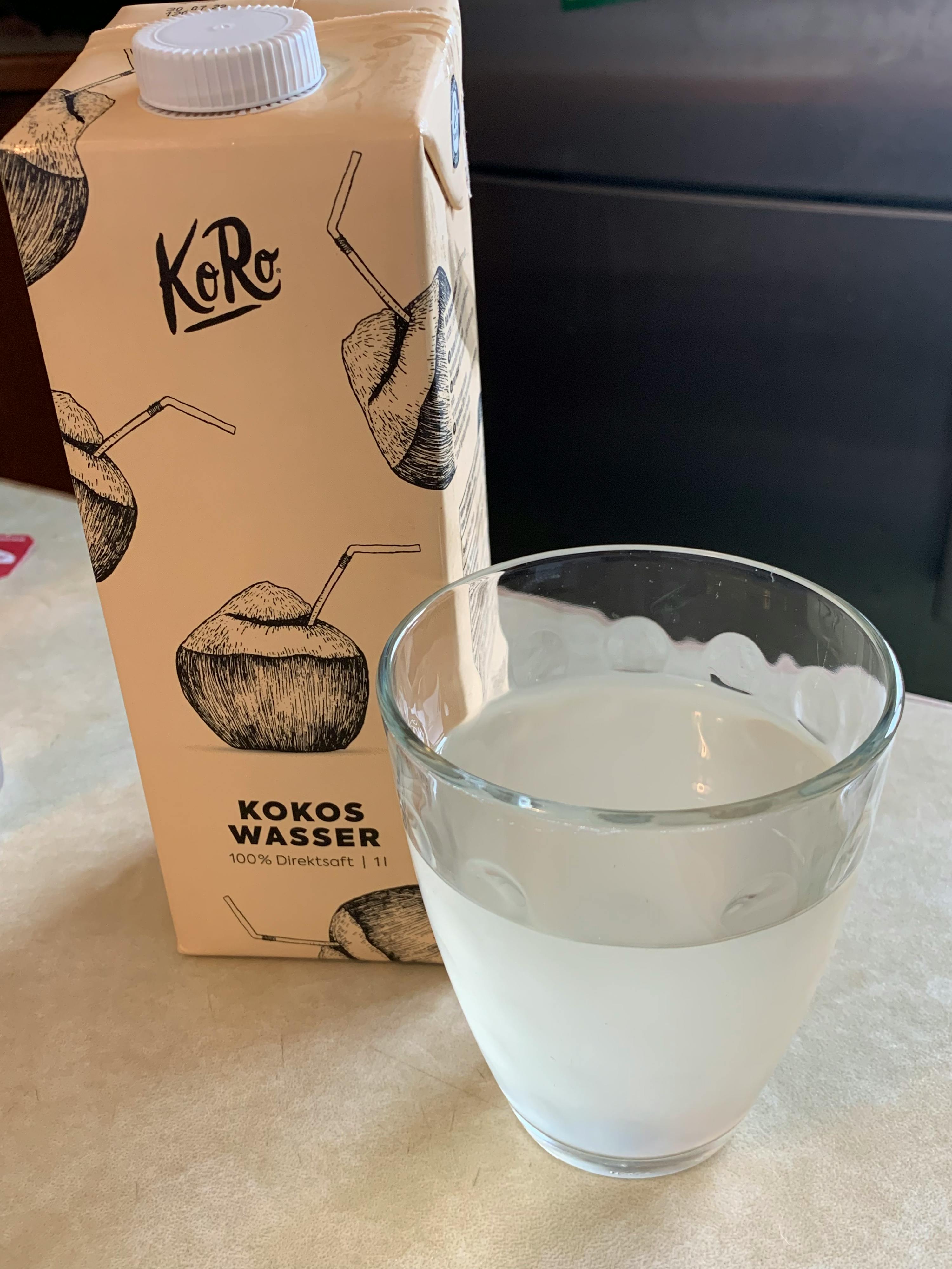 a carton of kokos wasser next to a glass
