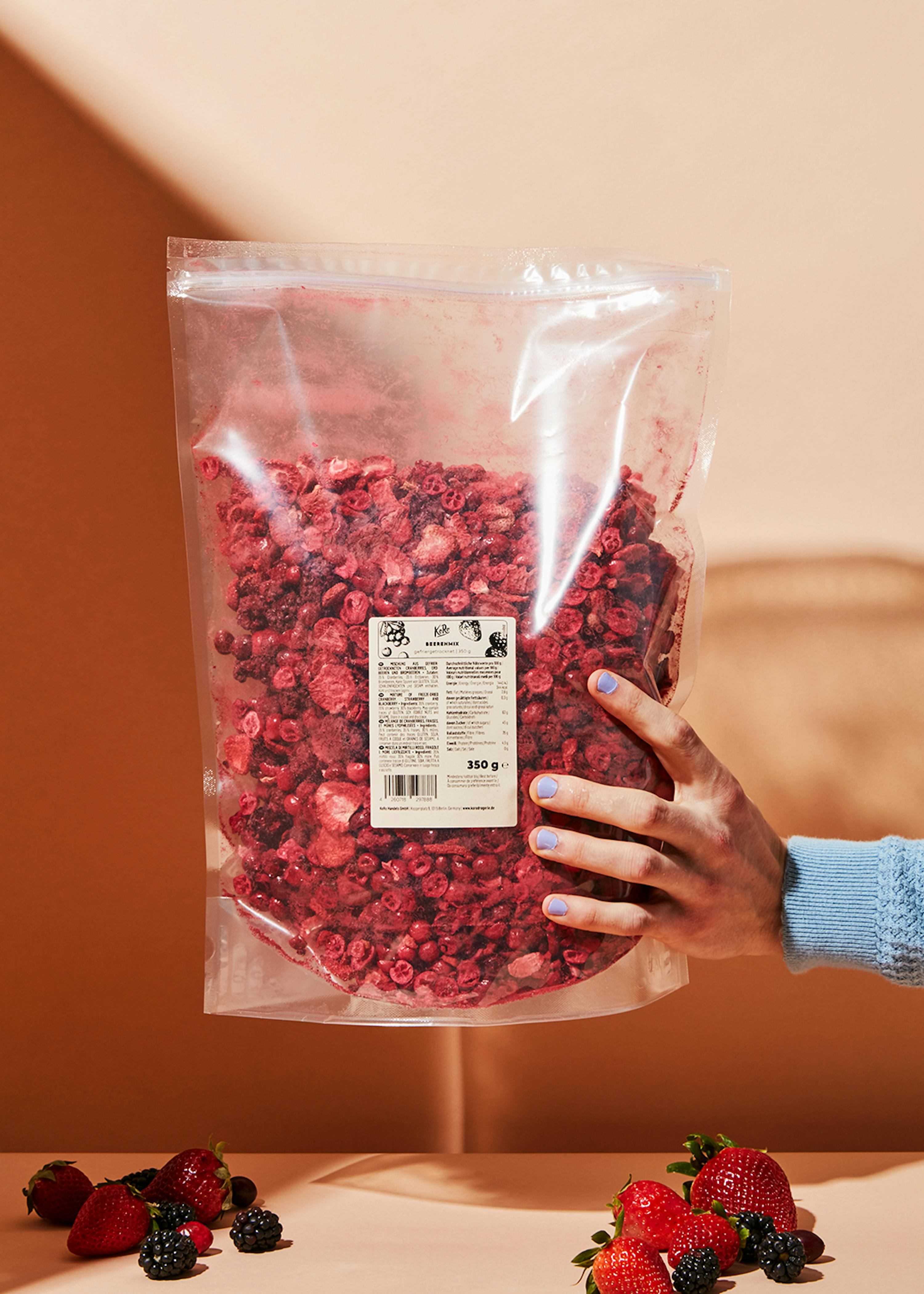 a person holding a bag of dried berries
