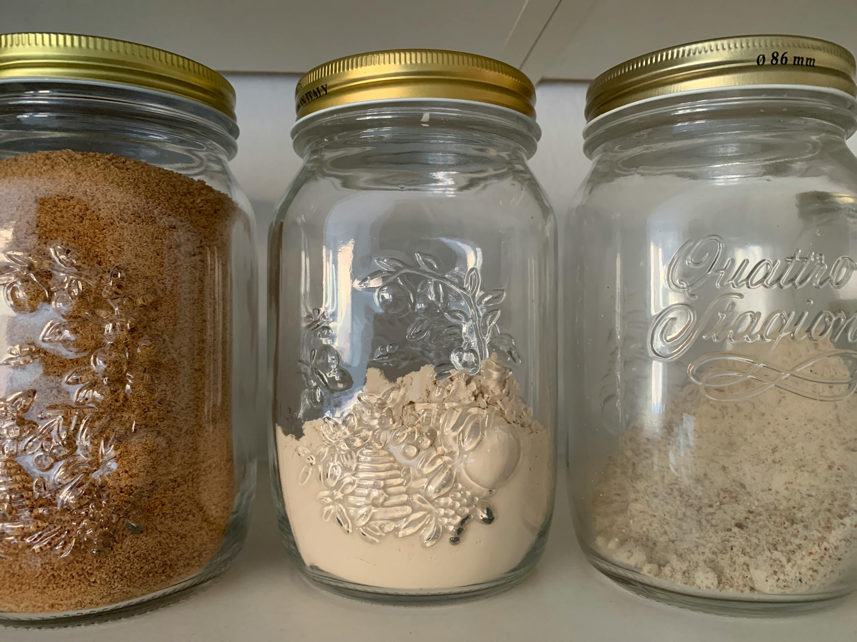 drei Gläser mit verschiedenen Zutaten in ihnen stehen auf einem Regal