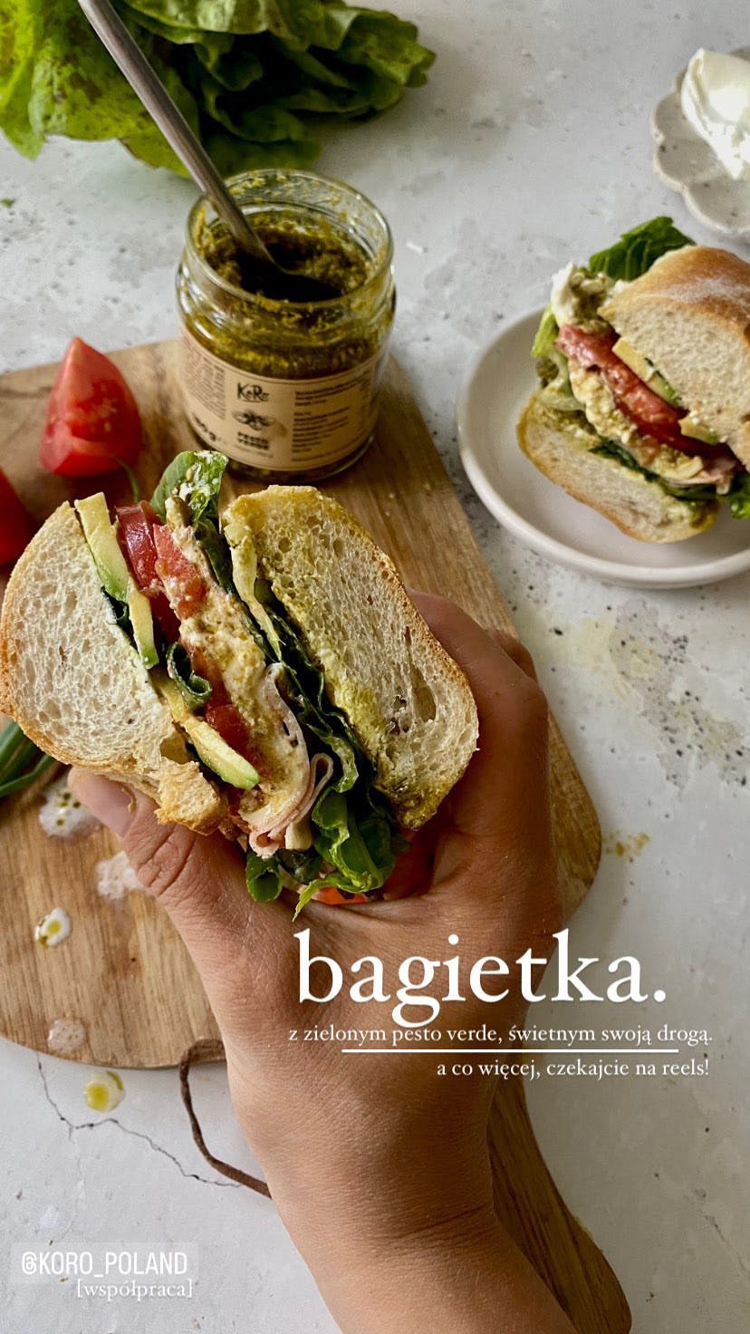 Eine Person hält ein Sandwich in ihrer Hand und trägt das Wort bagietka darunter