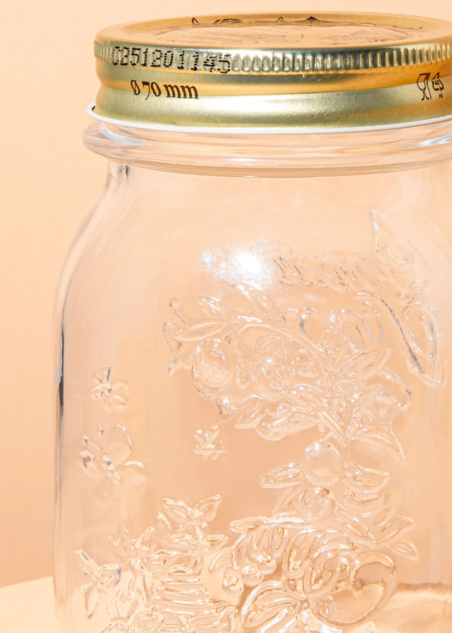 ein Glasgefäß mit einem goldenen Deckel und der Aufschrift 0750 mm