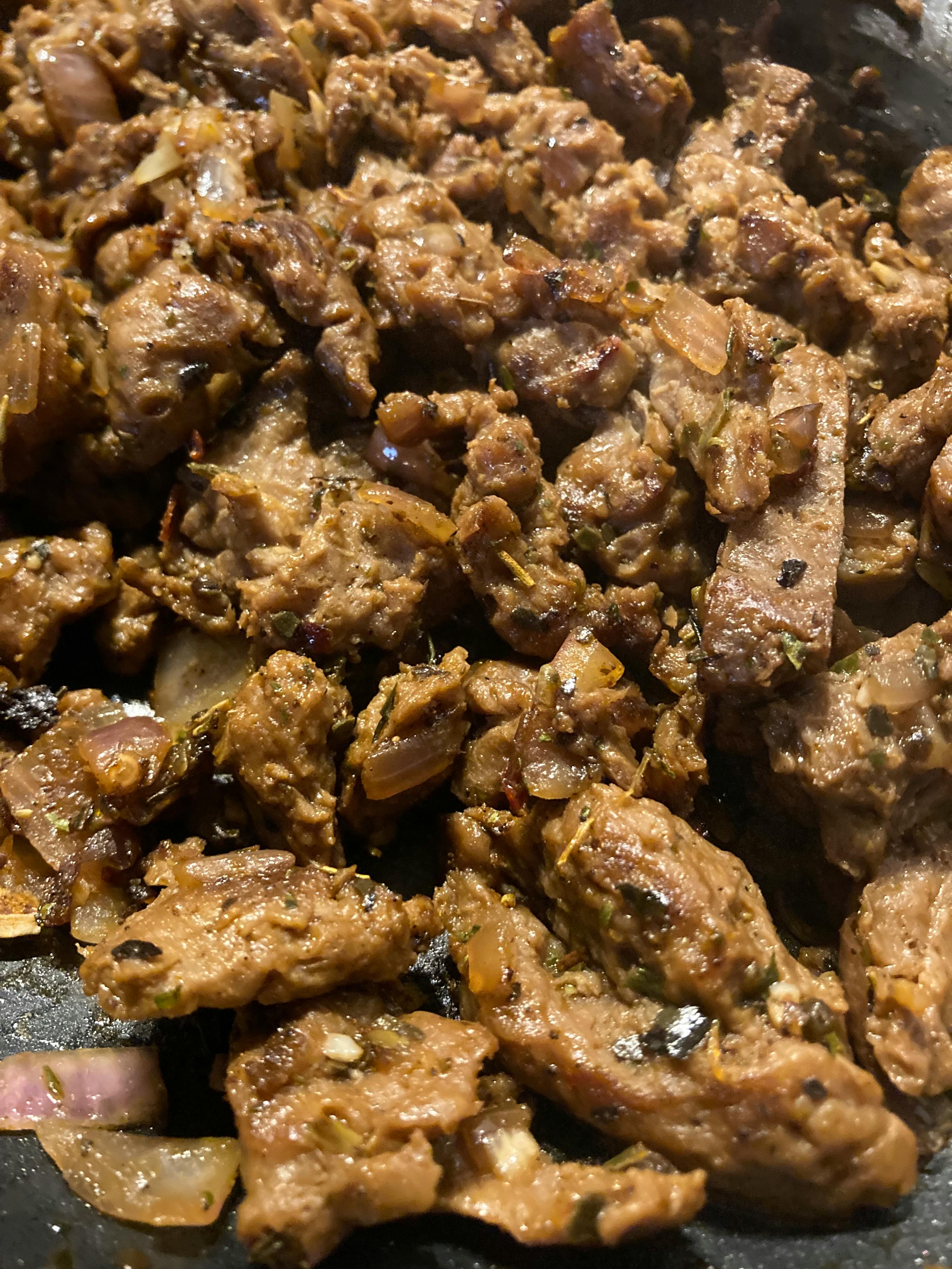 un primo piano di una padella piena di carne e cipolle