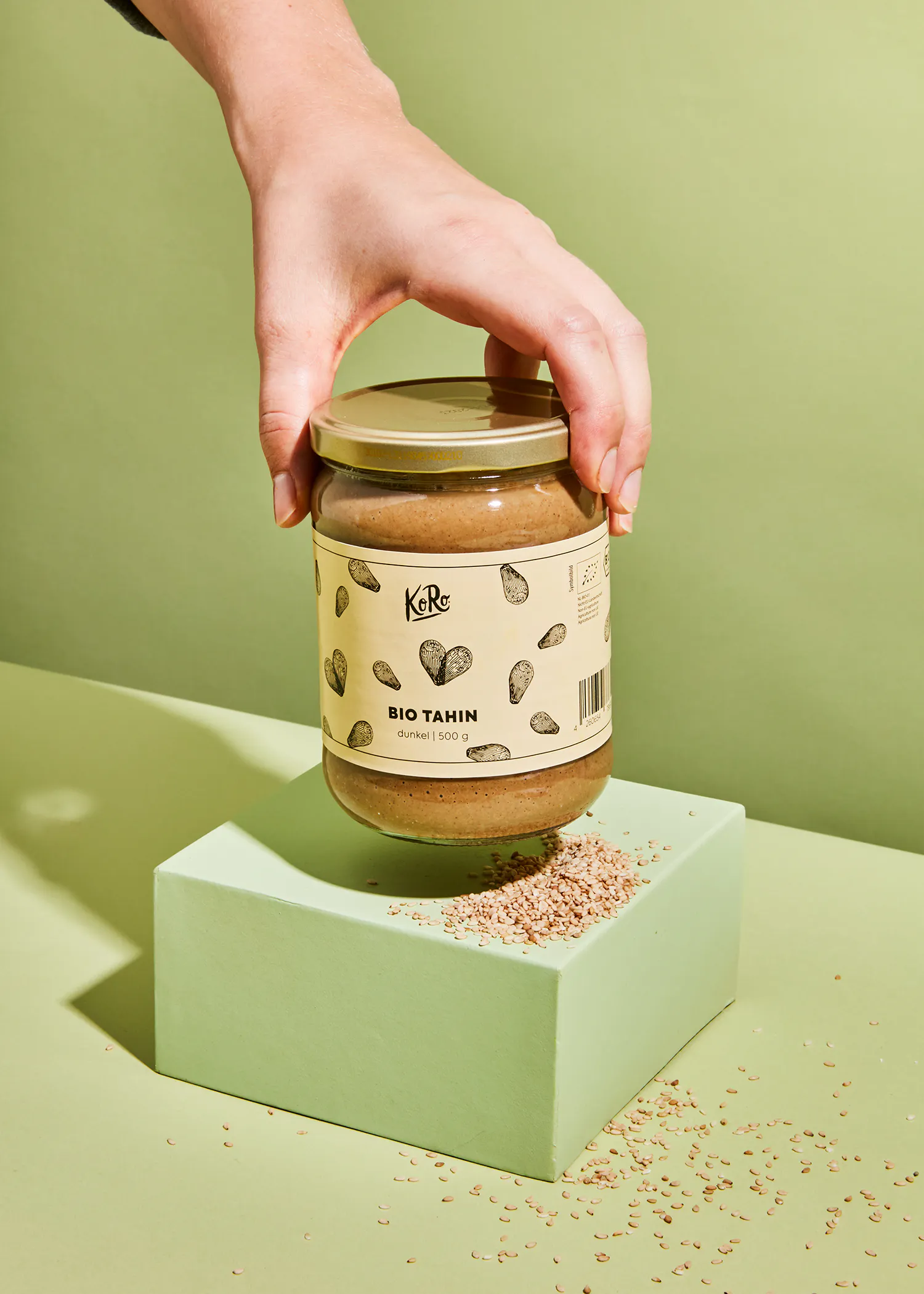 a jar of bio tahin is being held by a hand