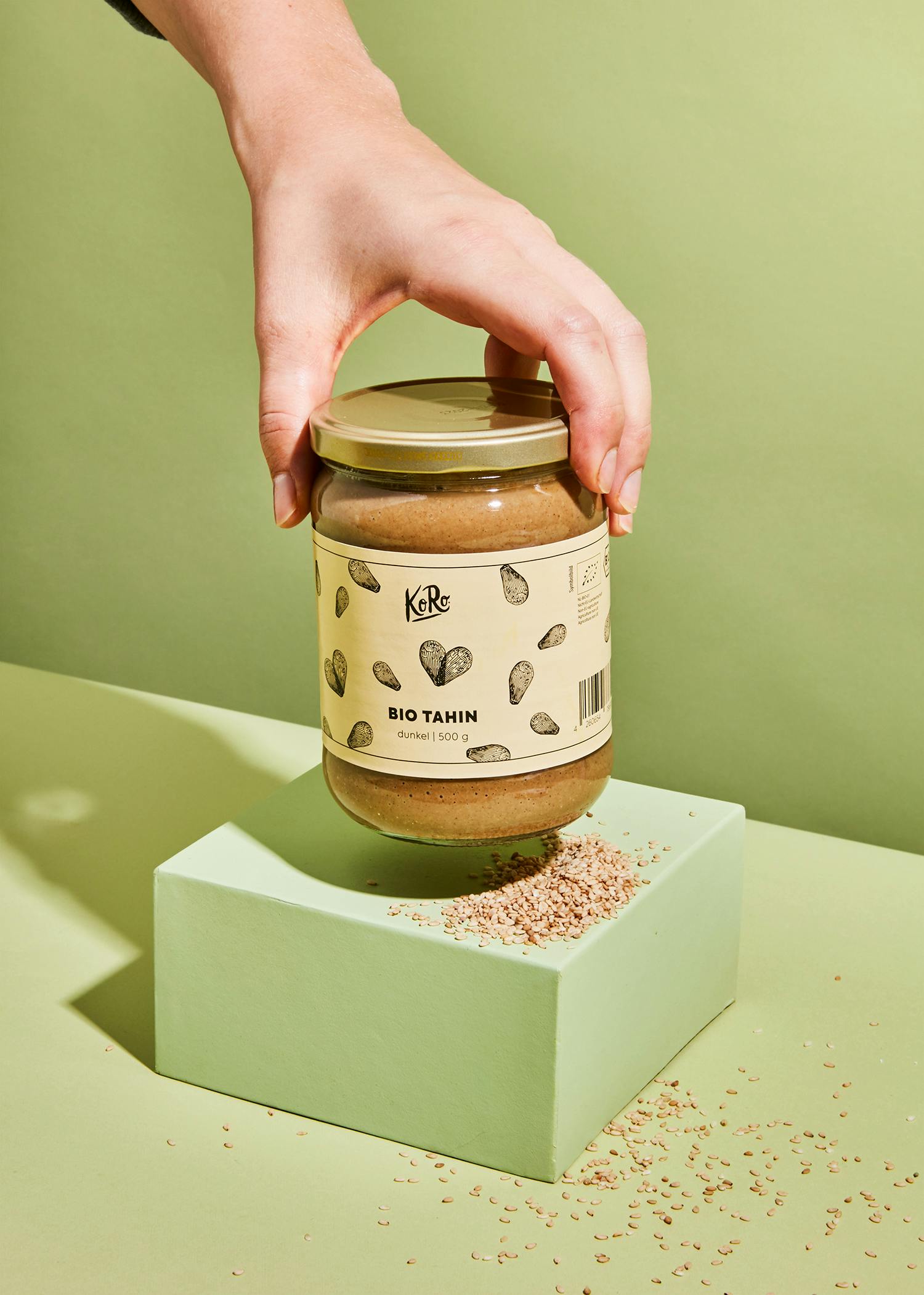 a jar of bio tahin is being held by a hand