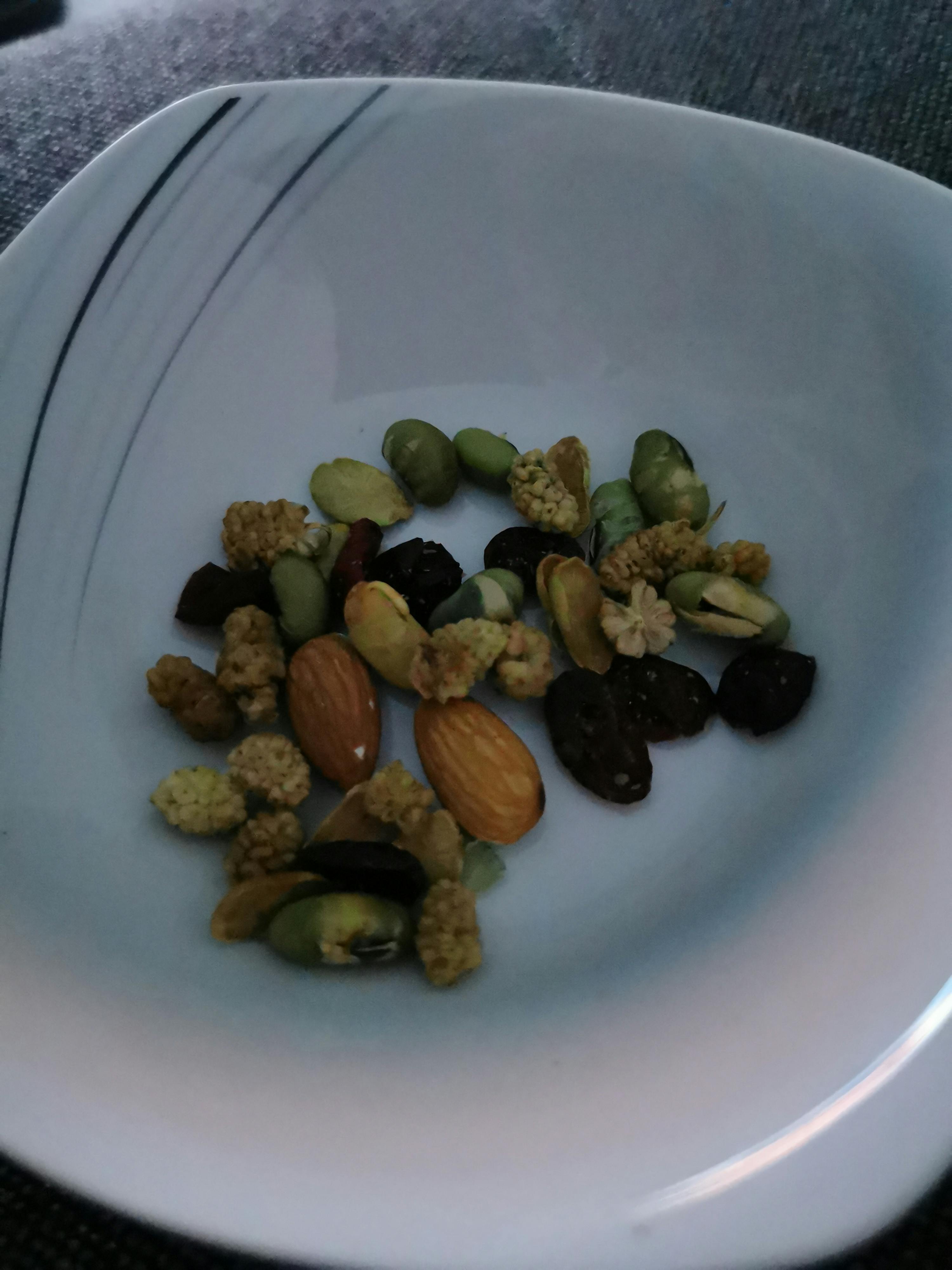 a white plate filled with nuts and seeds on a table