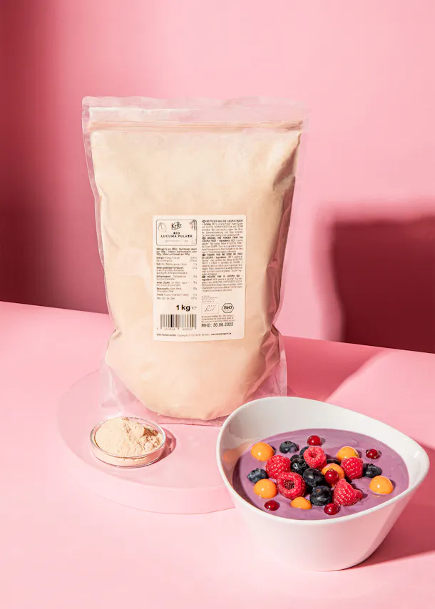 eine weiße Schüssel mit Früchten steht neben einer Tüte Pulver