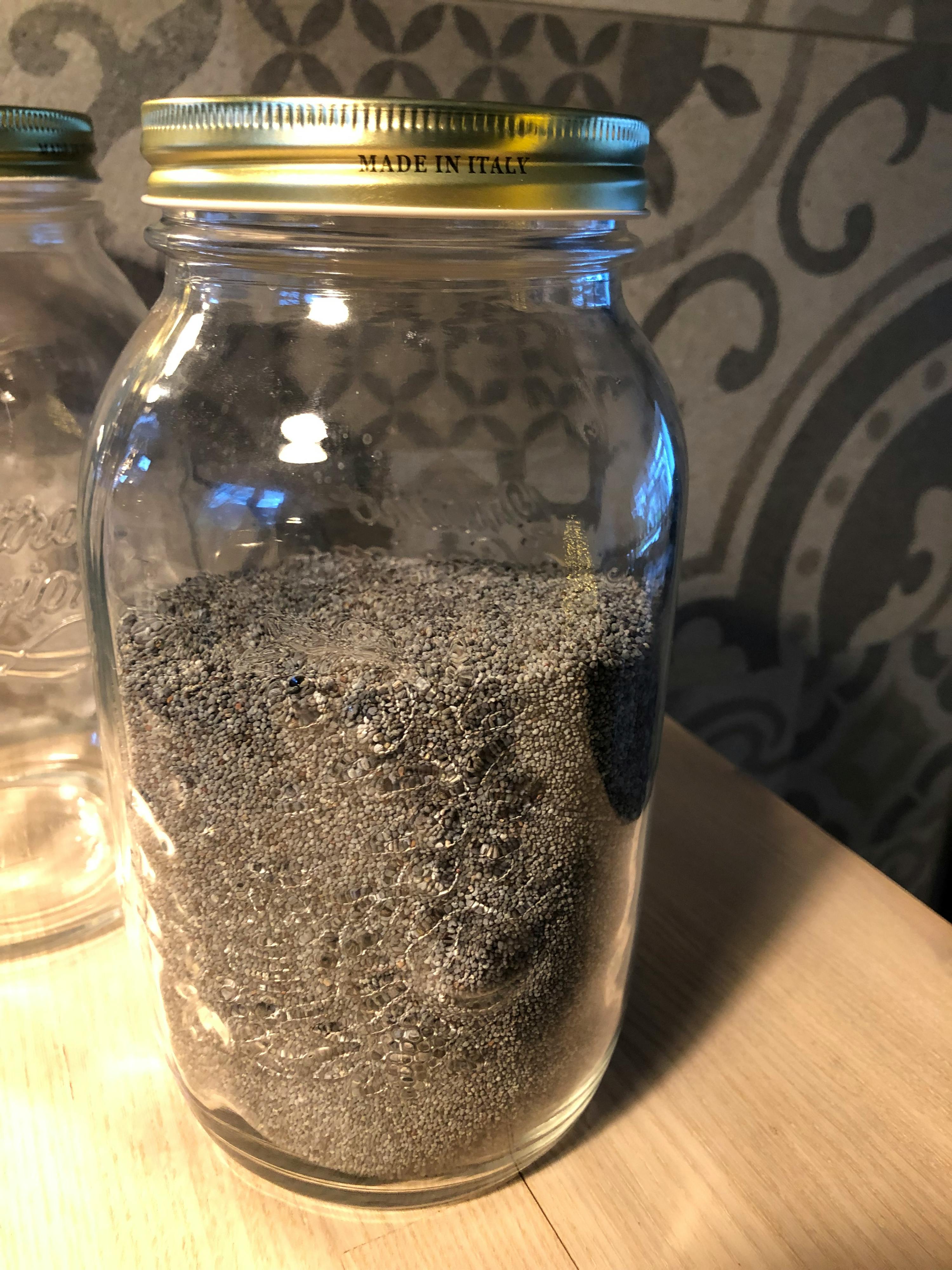 a glass jar with a metal lid that says made in italy