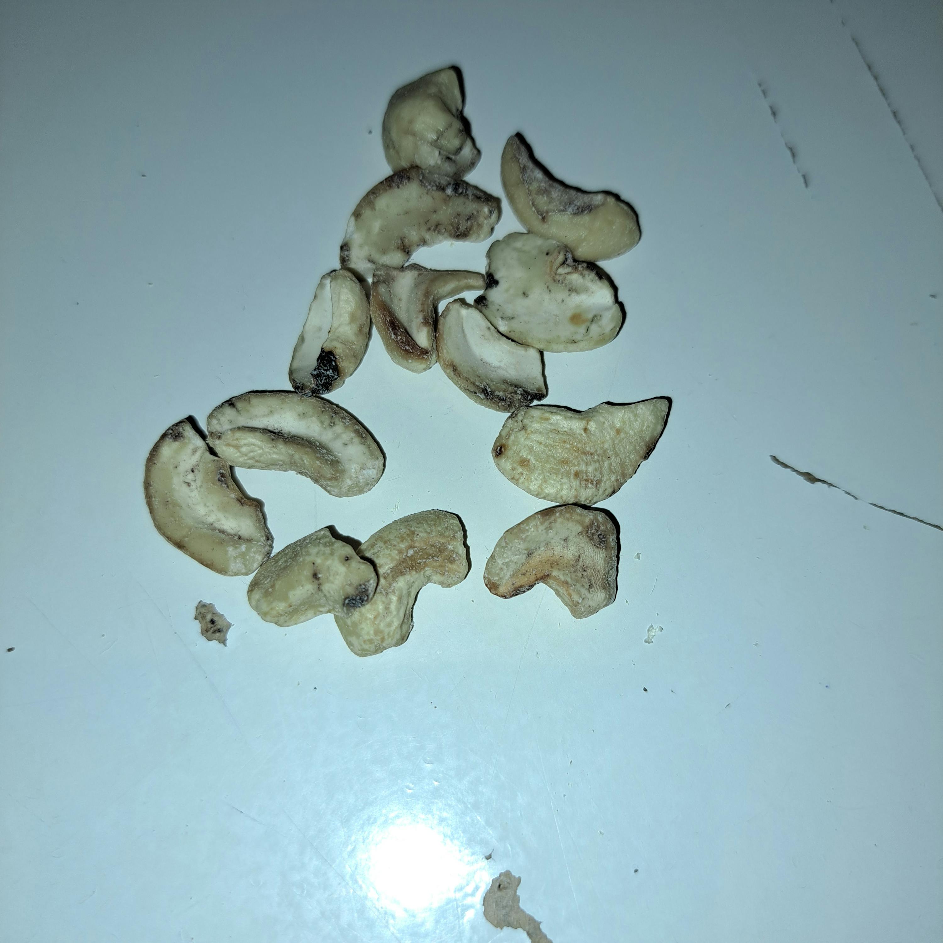 a pile of cashews on a white surface