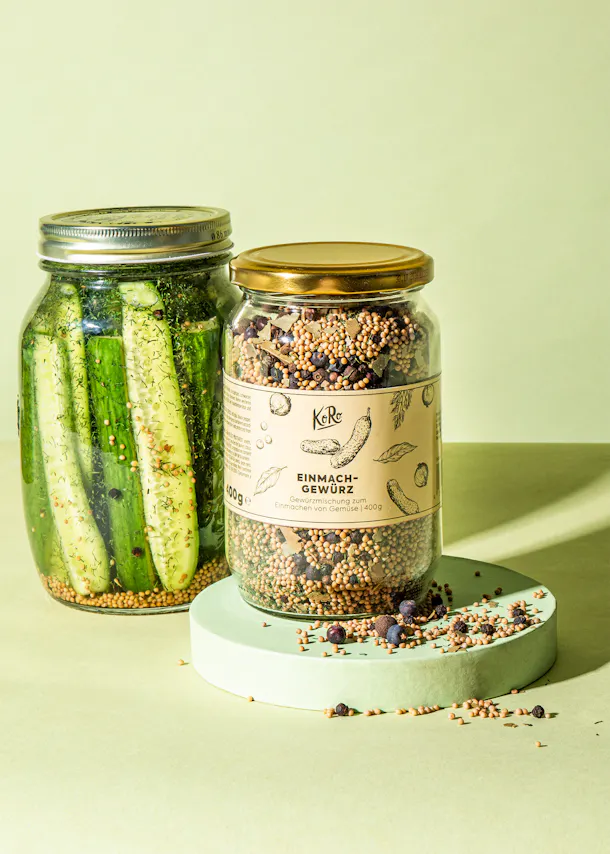 a jar of einmach gewurz sits next to a jar of pickles