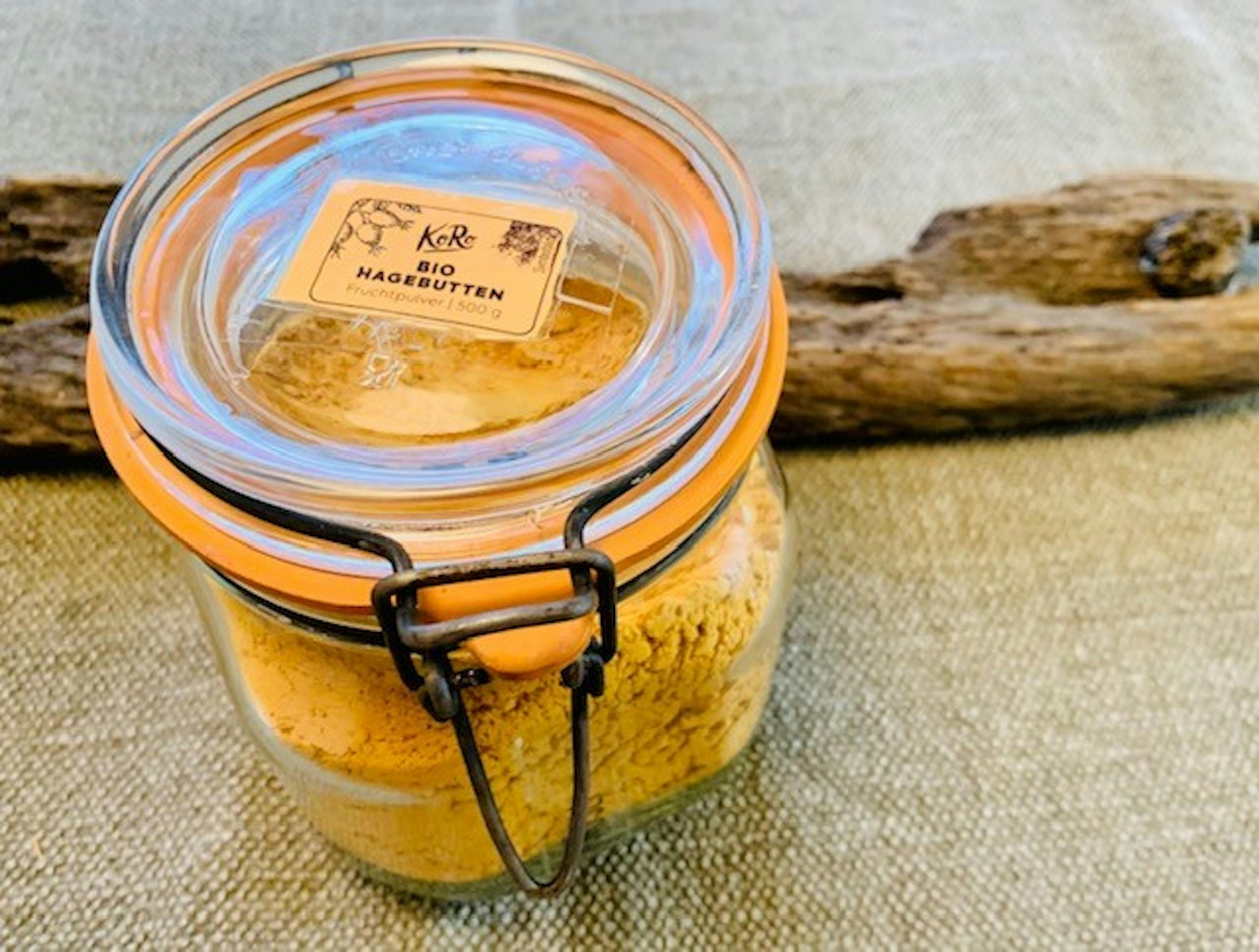 ein Glas mit orangefarbenem Deckel und einem Etikett , das sagt hagebutten