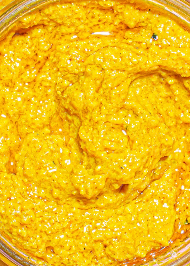 eine Nahaufnahme einer gelben Soße in einer Glasschüssel