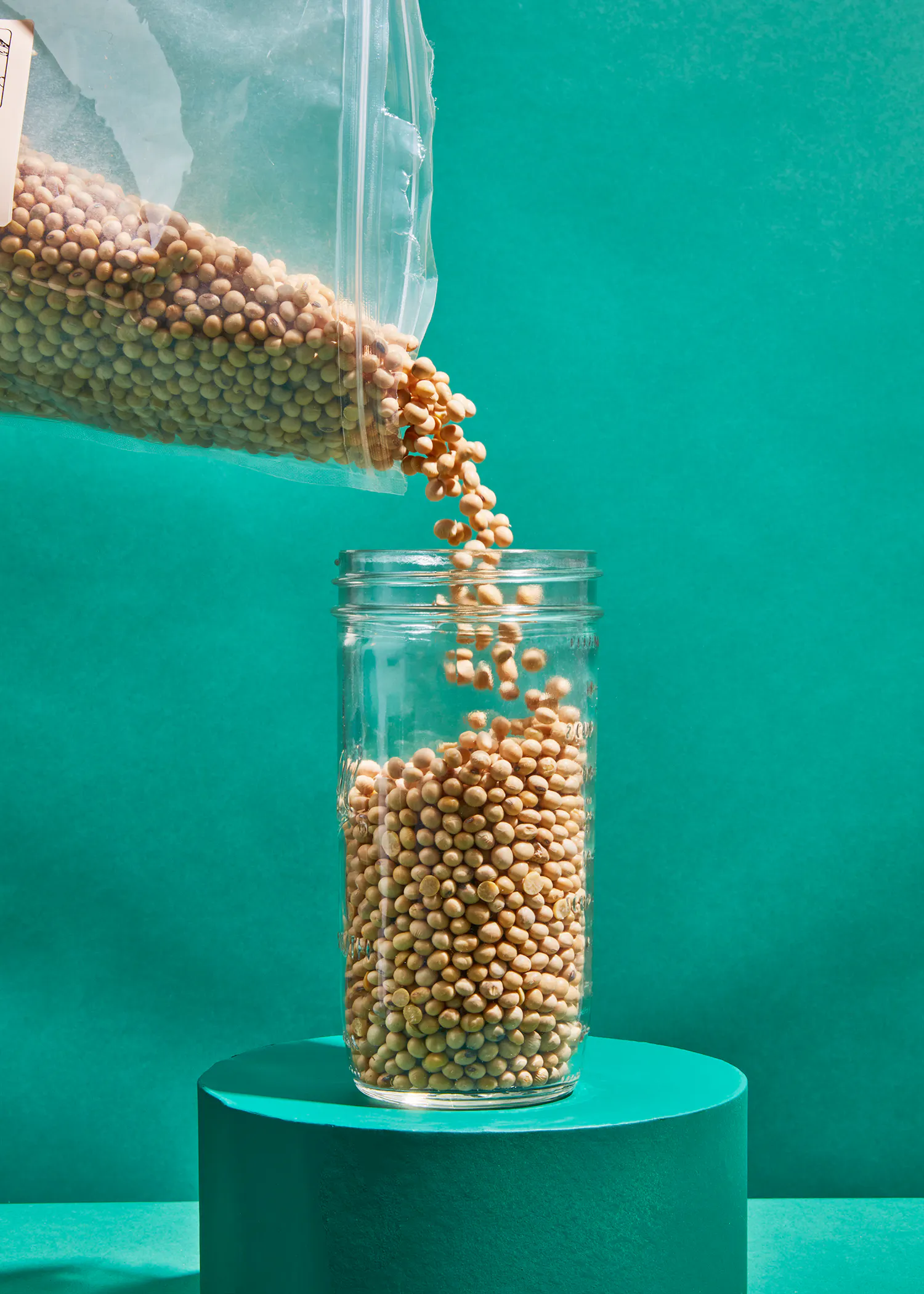 eine Tüte Linsen wird in ein Glas gefüllt