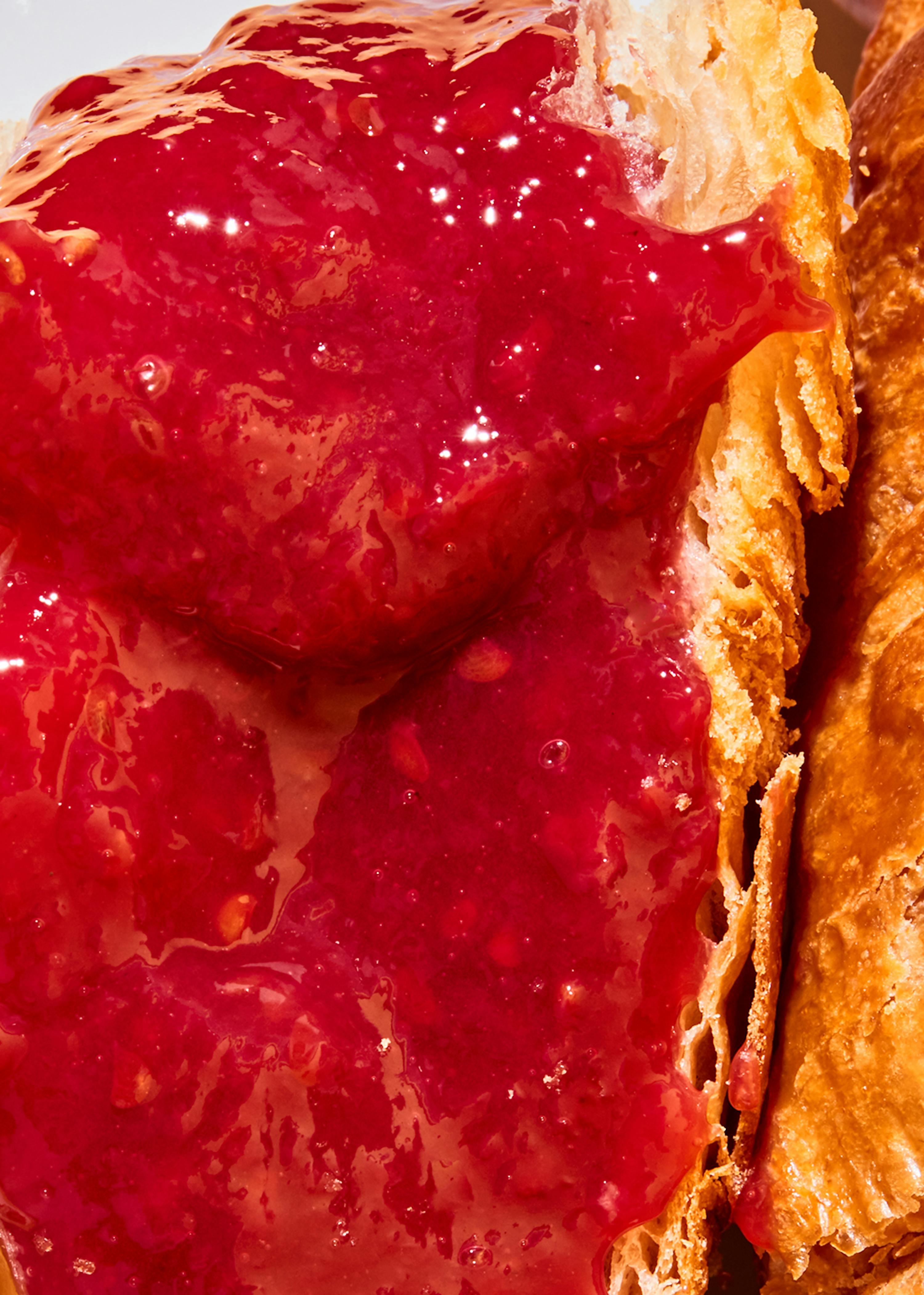 un gros plan d' un croissant avec de la confiture sur le dessus