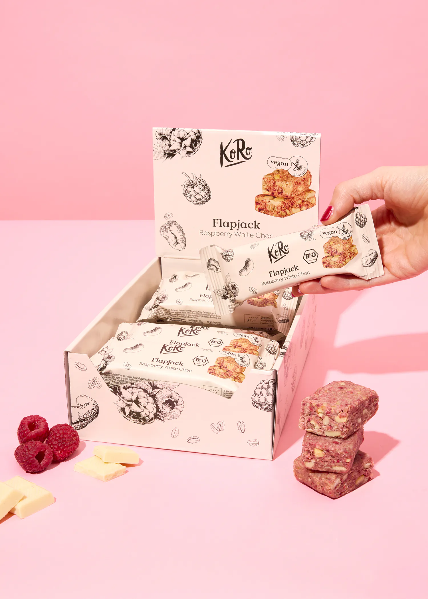 eine Person hält eine flapjack-Raspberry-White-Cacao-Bar in der Hand