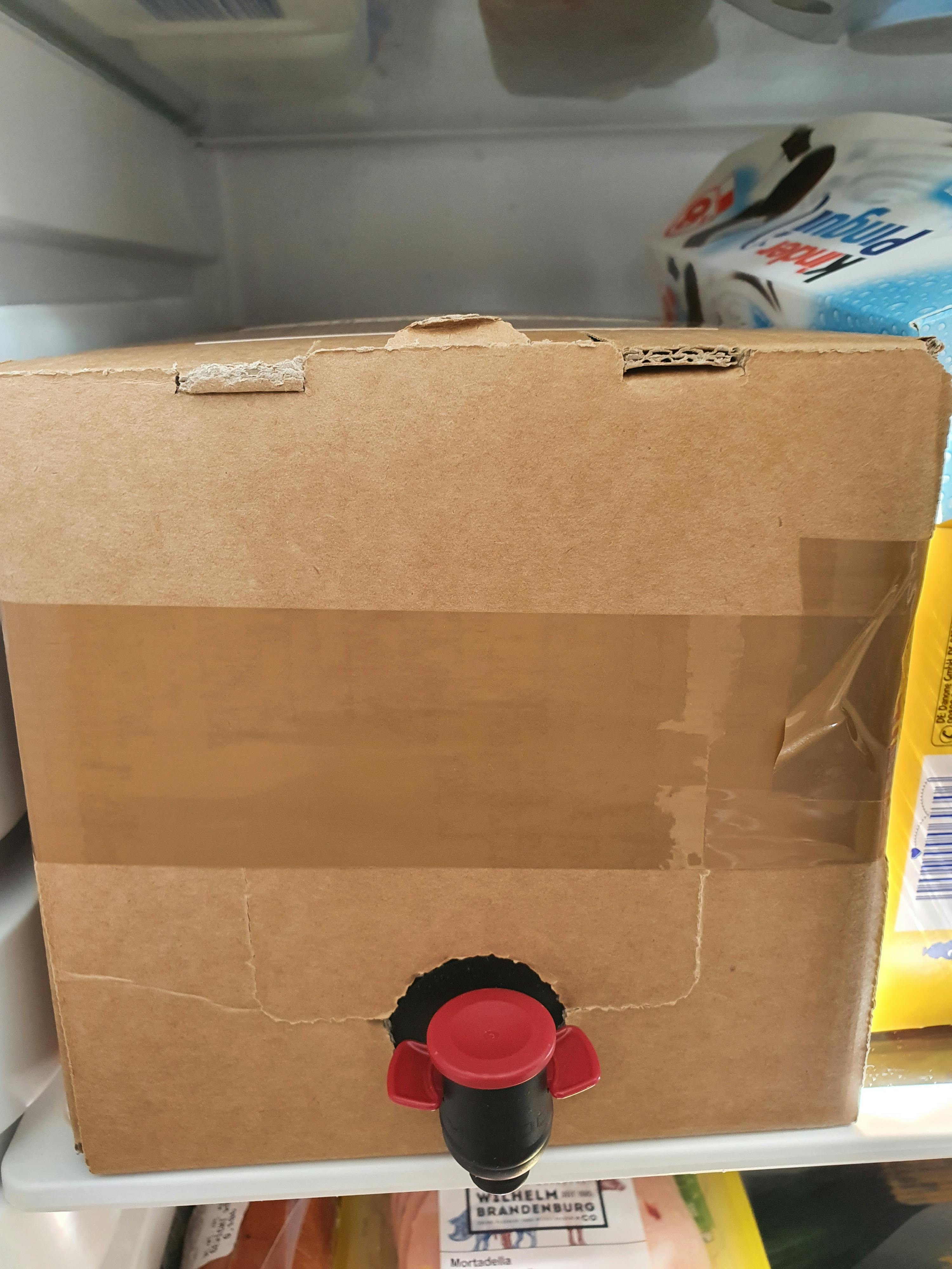 une boîte en carton avec un robinet rouge à l' intérieur