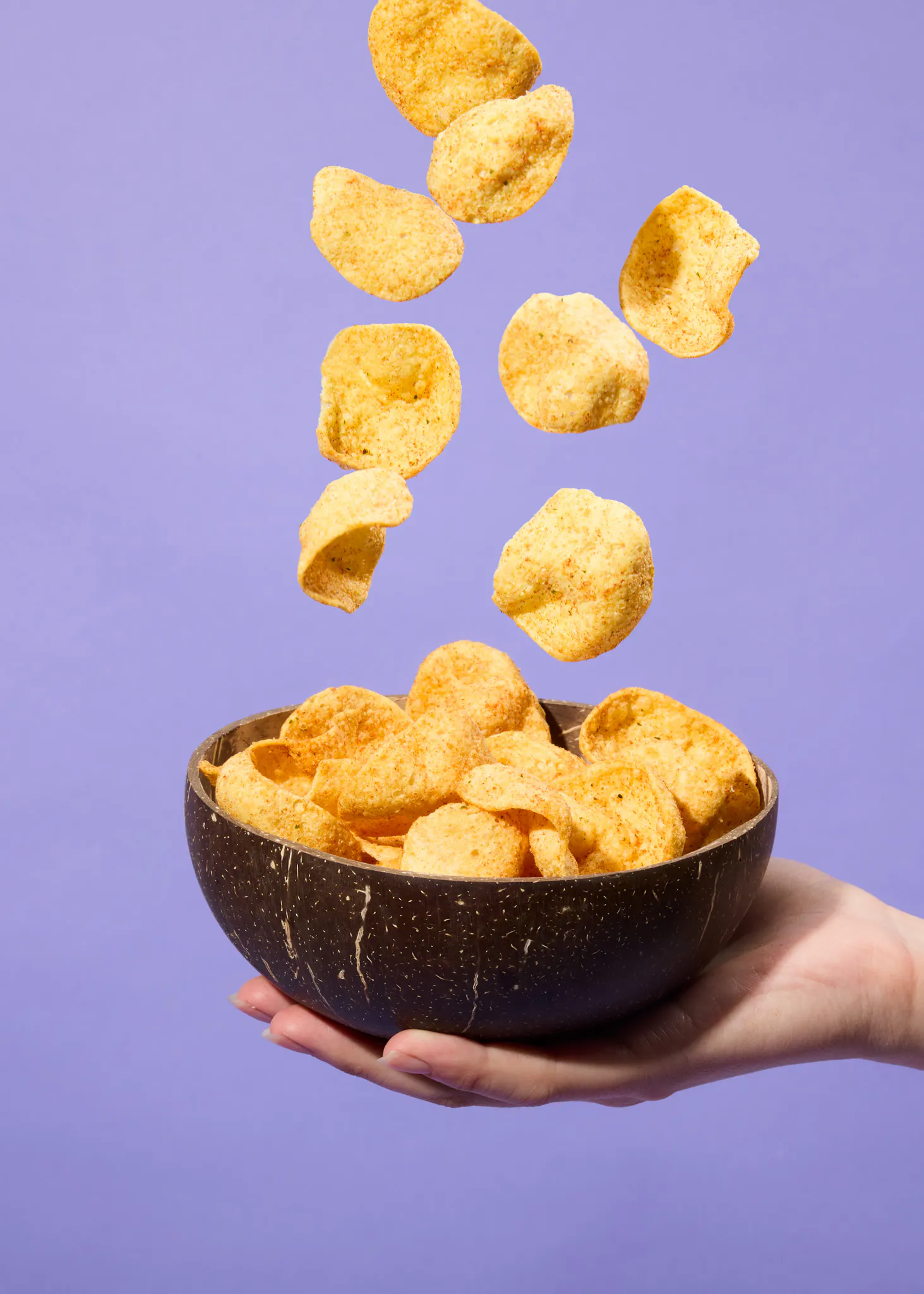 eine Person hält eine Schüssel mit Kartoffelchips in der Hand