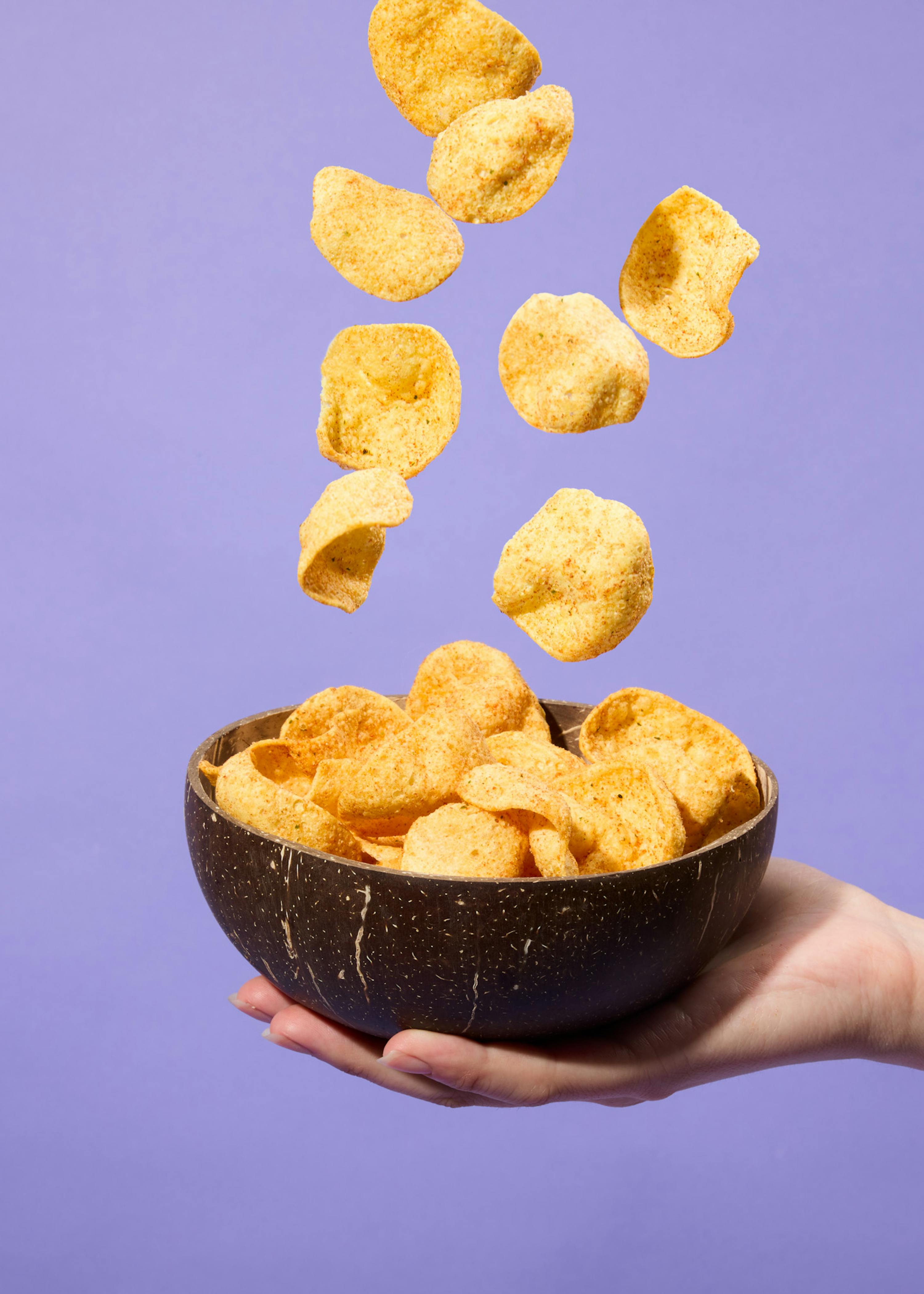 eine Person hält eine Schüssel mit Kartoffelchips in der Hand