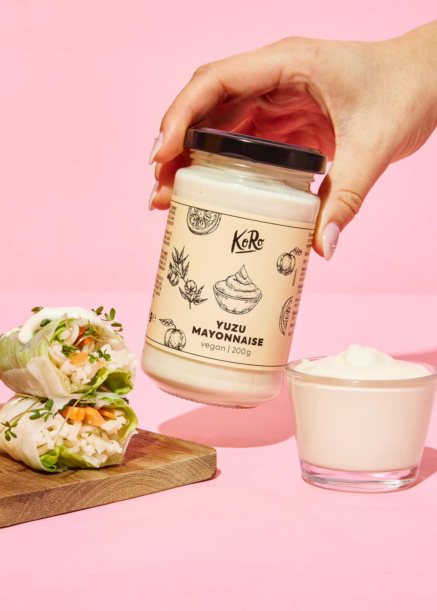 une personne tient un bocal de mayonnaise à côté d' un bol de mayonnaise