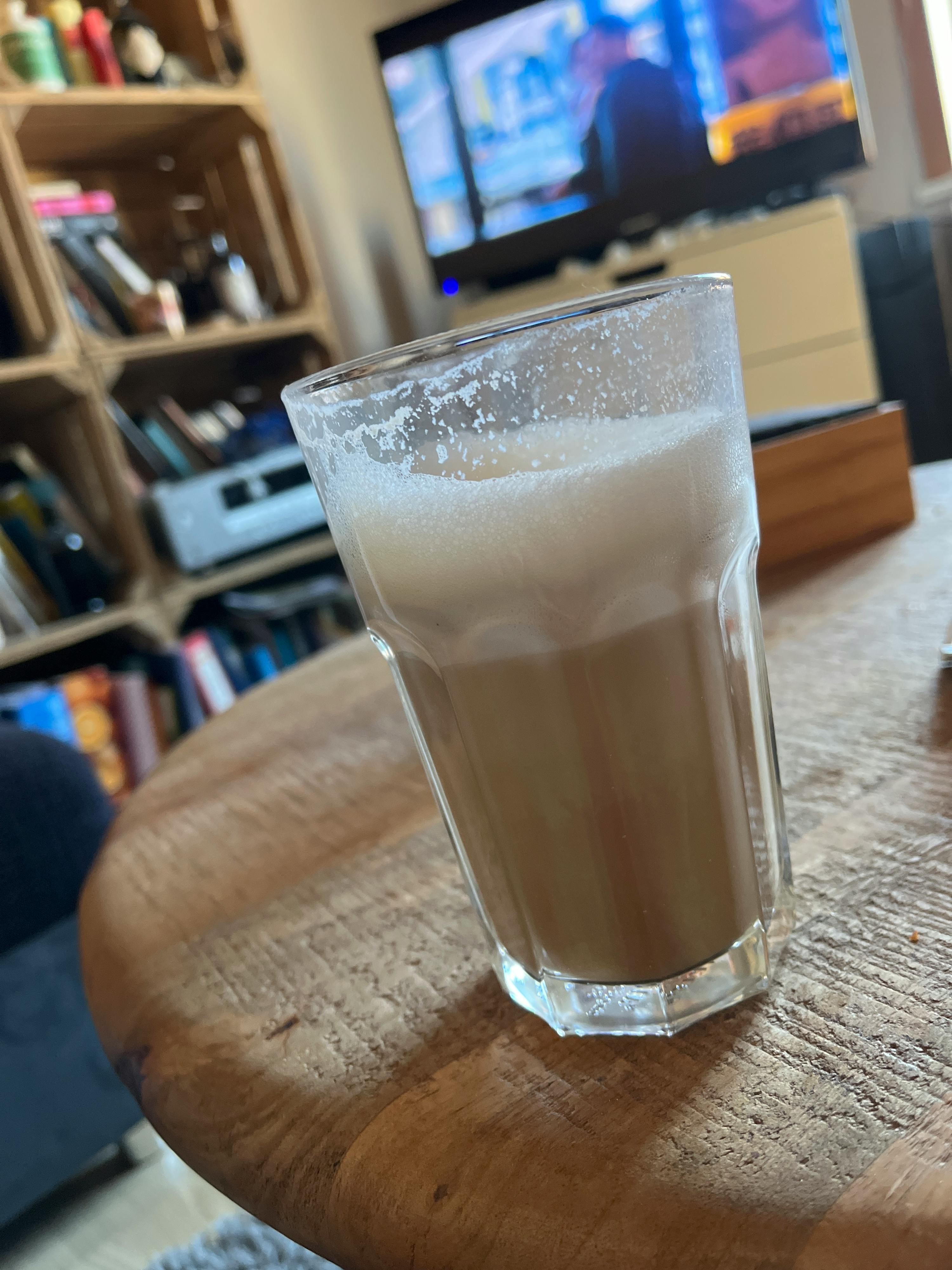 a glass of milk is sitting on a wooden table