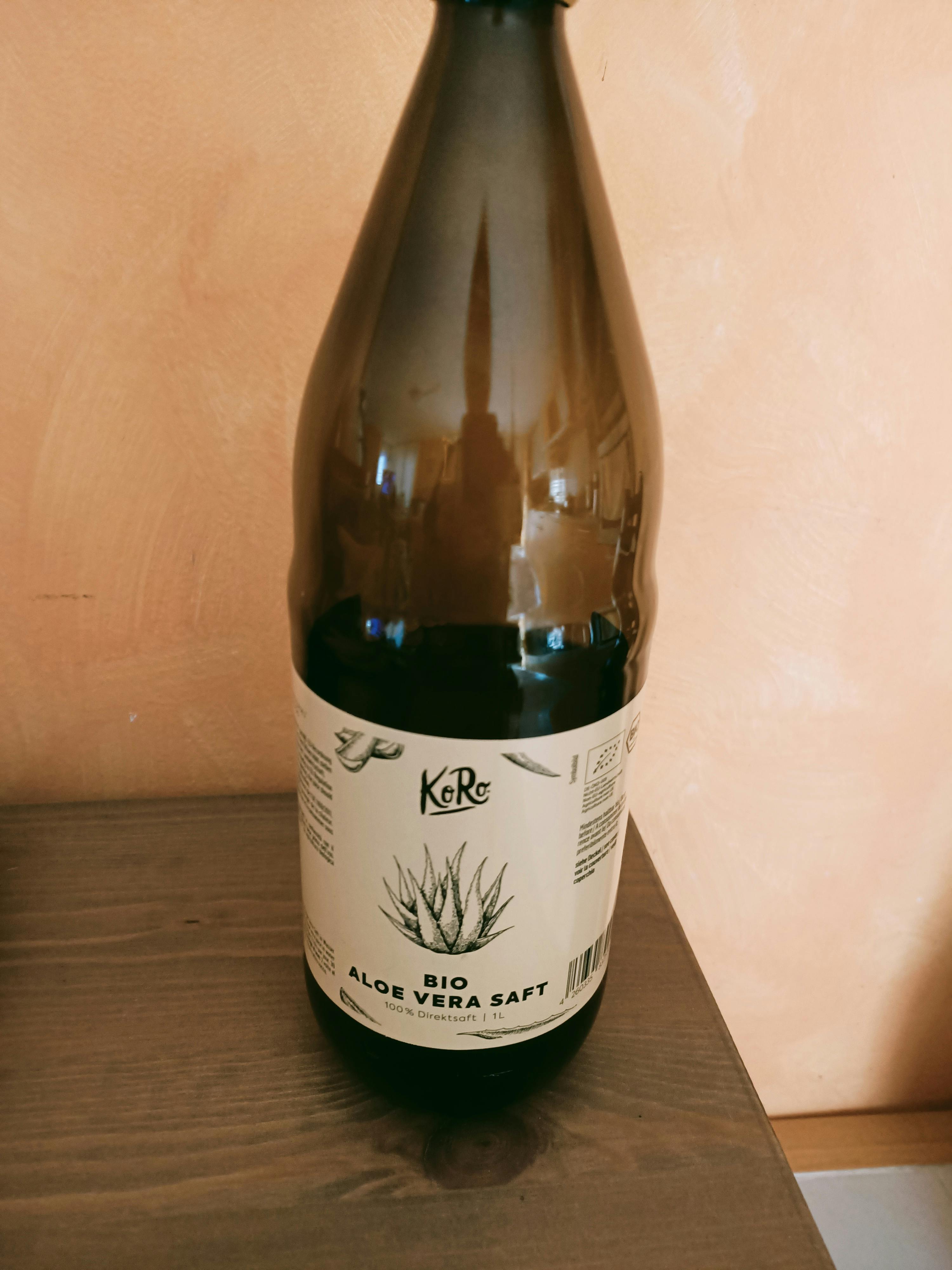 une bouteille d' aloe vera saft bio est assise sur une table en bois