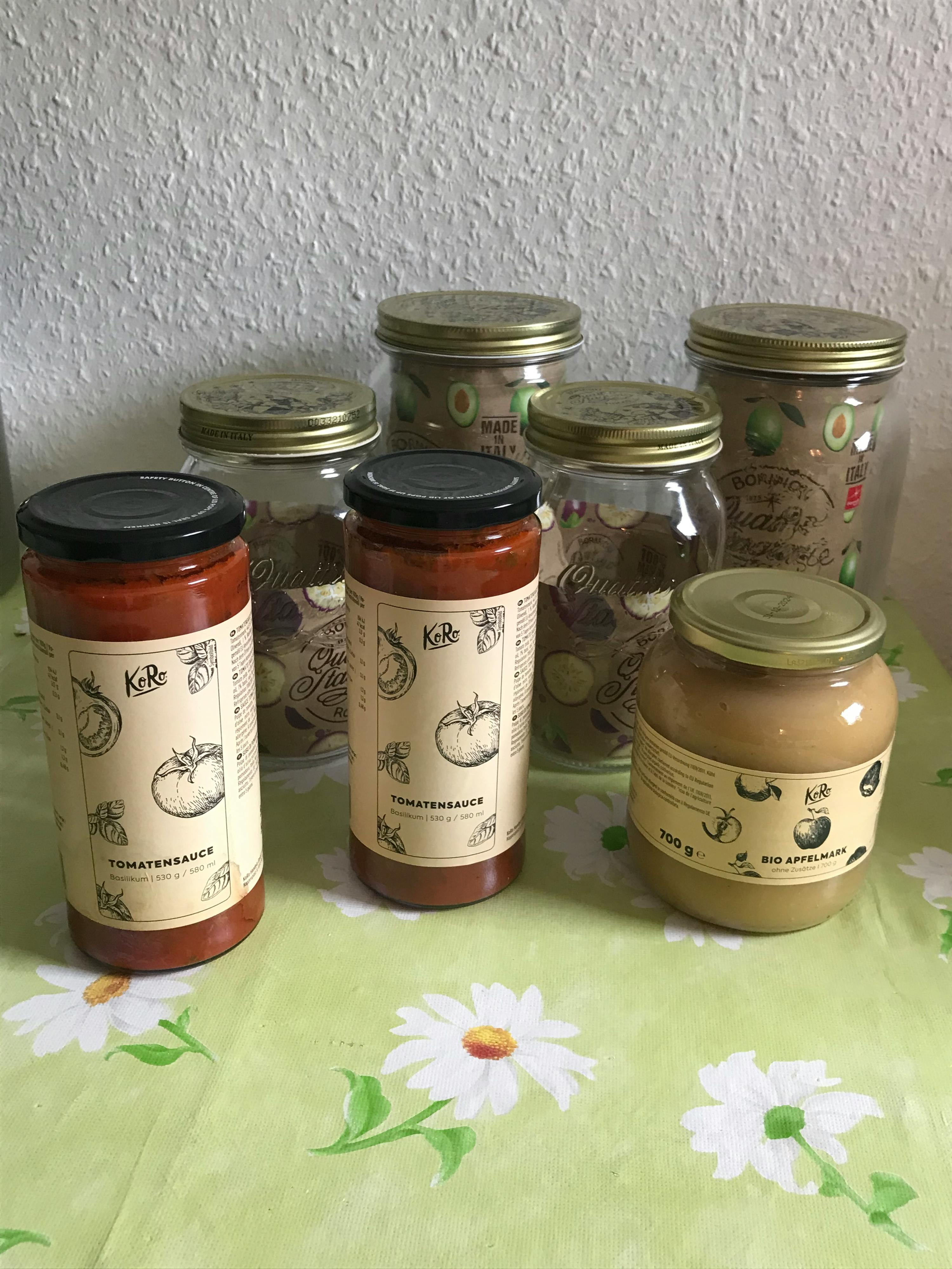 tre vasetti di salsa sono seduti uno accanto all'altro su un tavolo