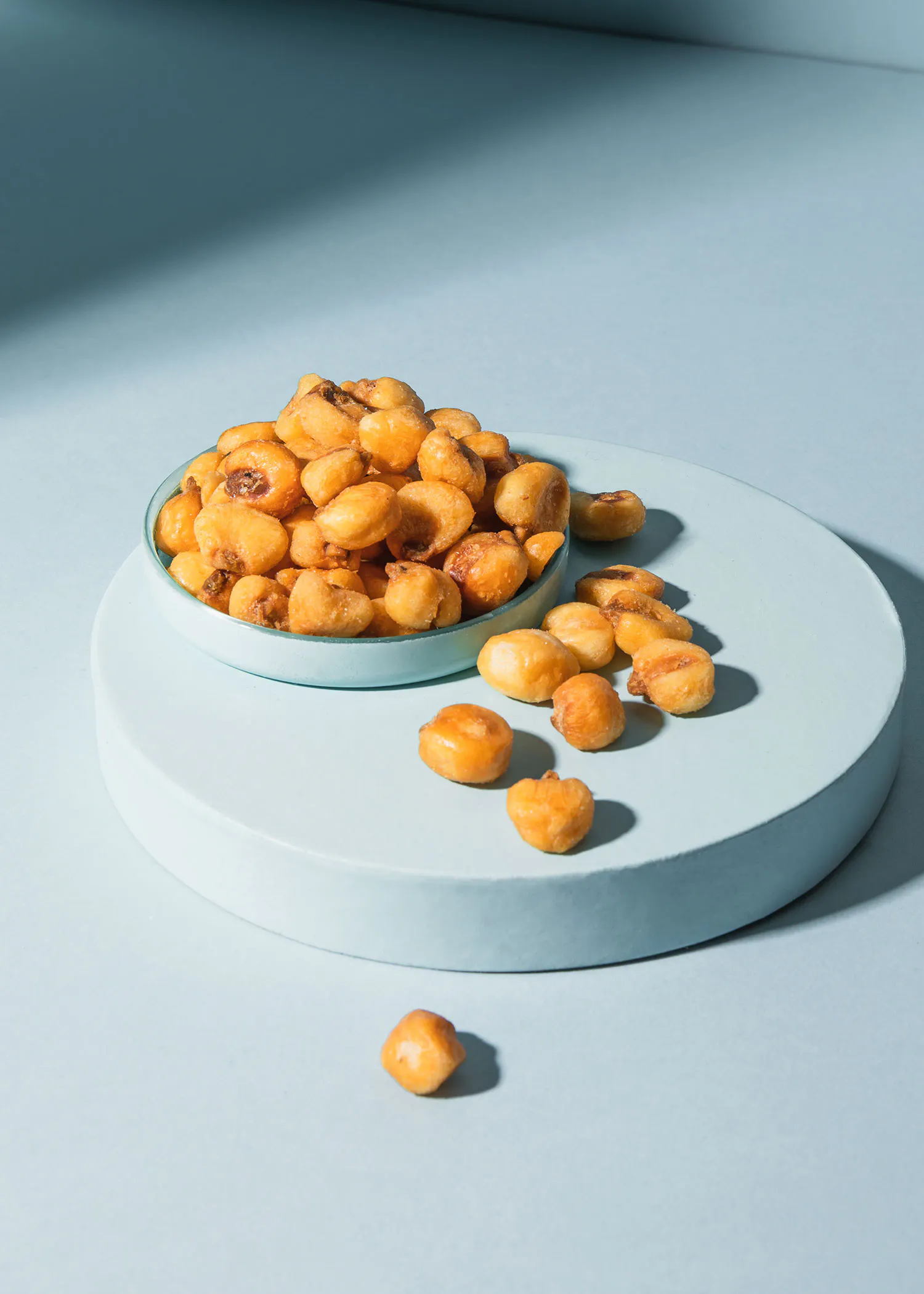 une assiette bleue remplie de maïs frit sur une surface bleue