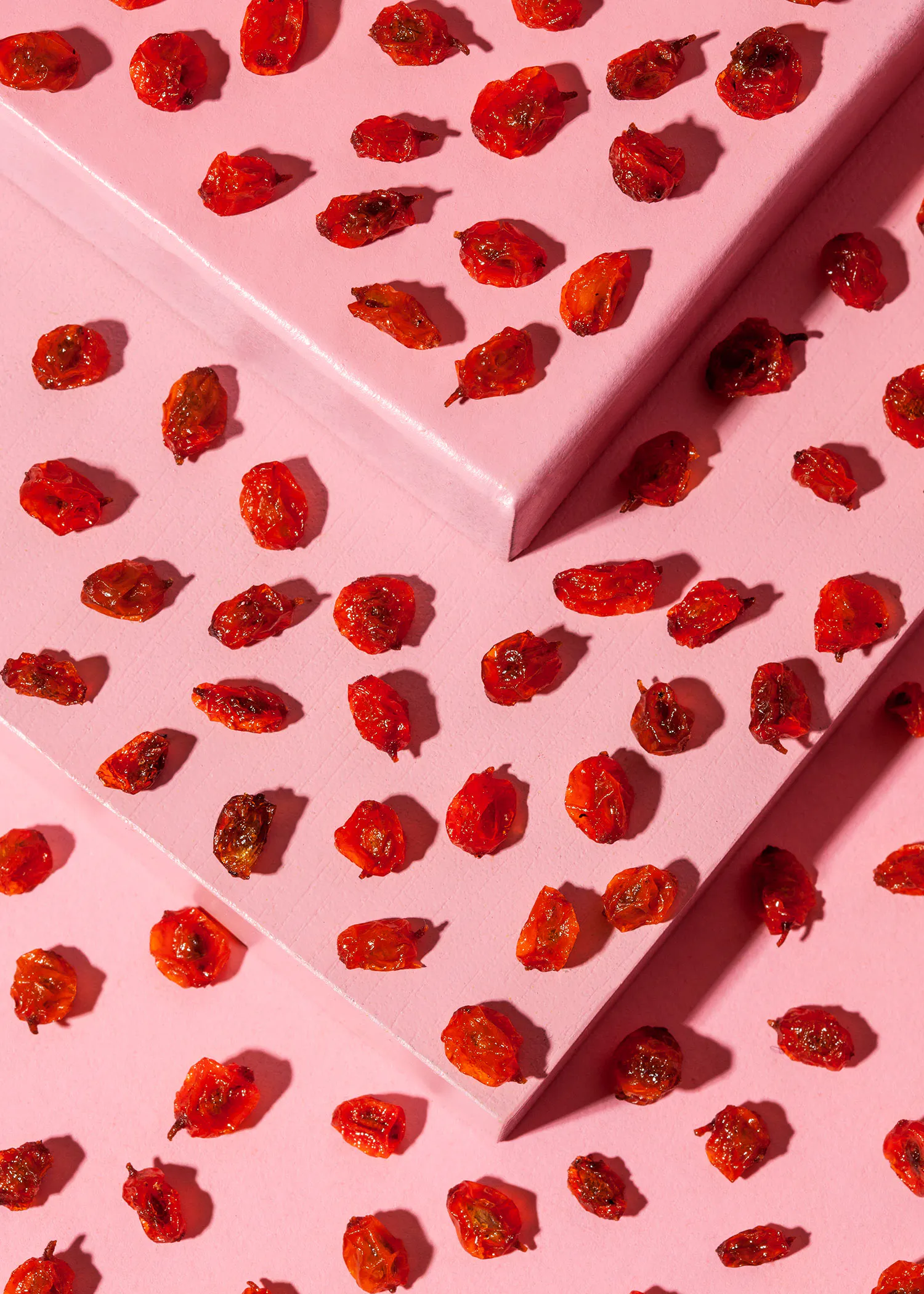 ein rosa Hintergrund mit getrockneten Tomaten darauf