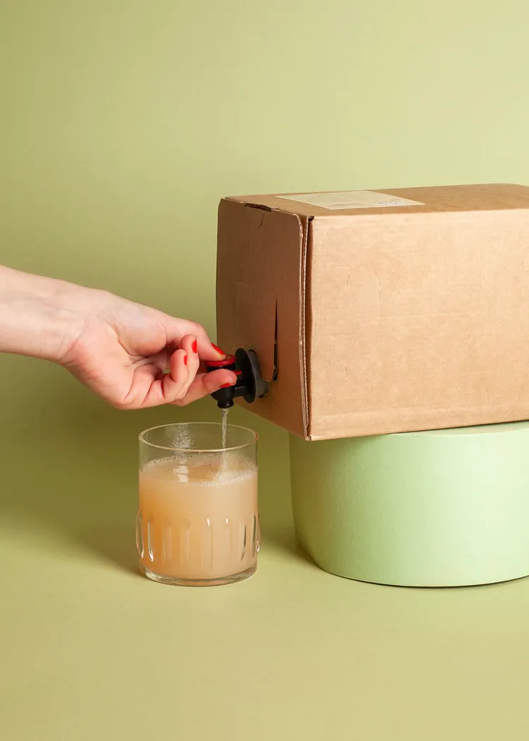 eine Person gießt einen Saft in ein Glas