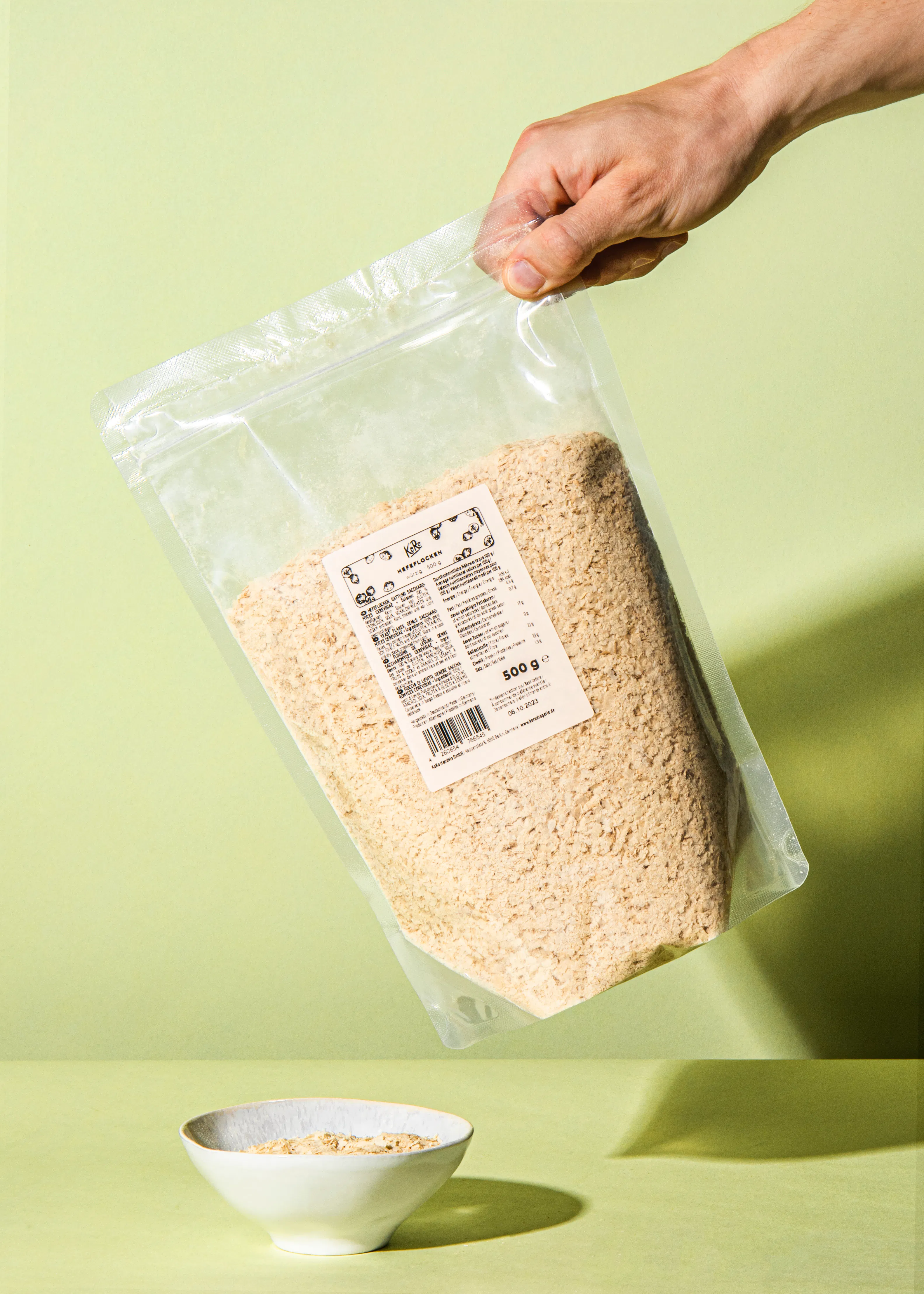 une personne tient un sac de flocons d' avoine à côté d' un bol