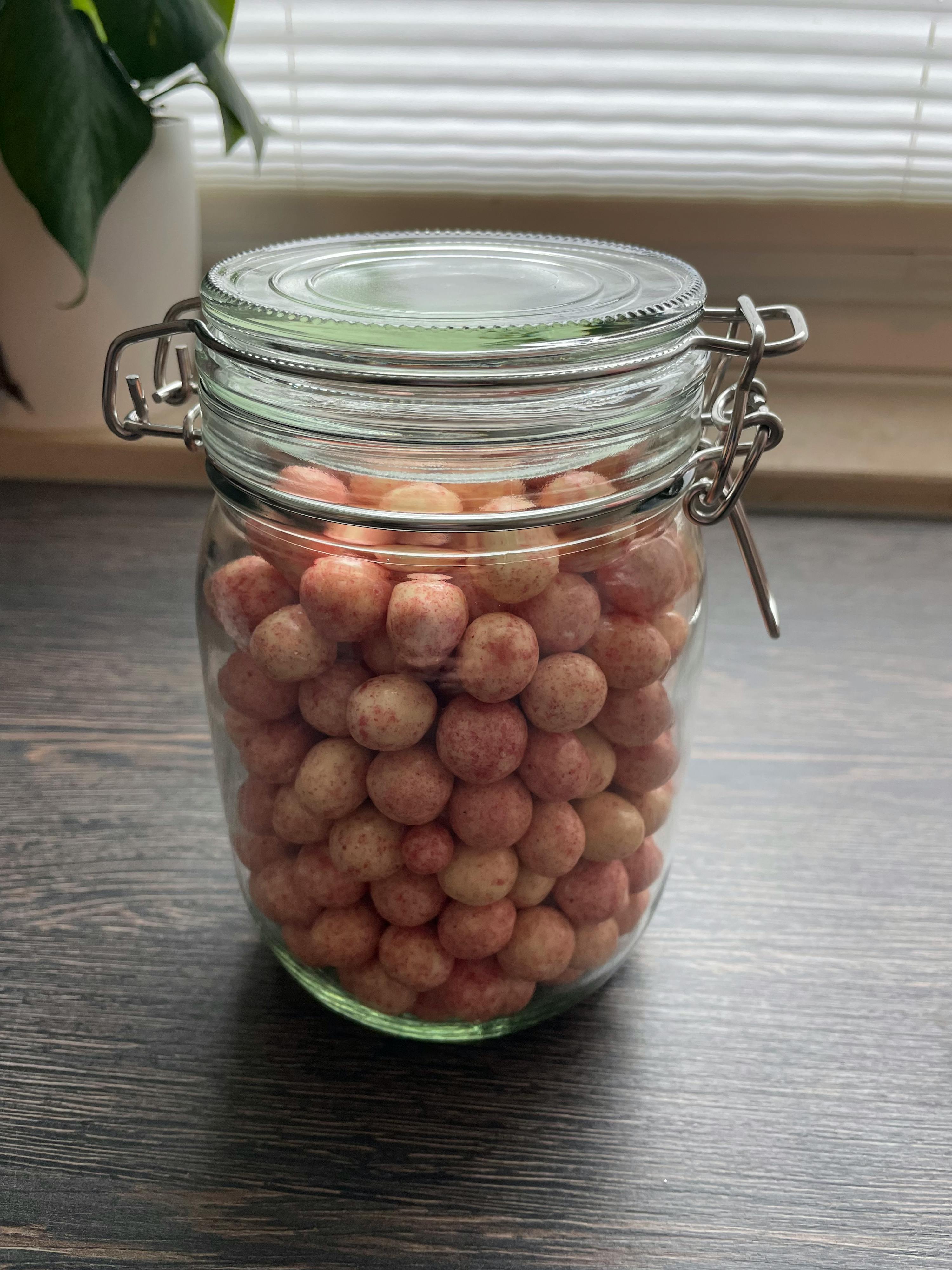 un barattolo di vetro pieno di caramelle su un tavolo di legno