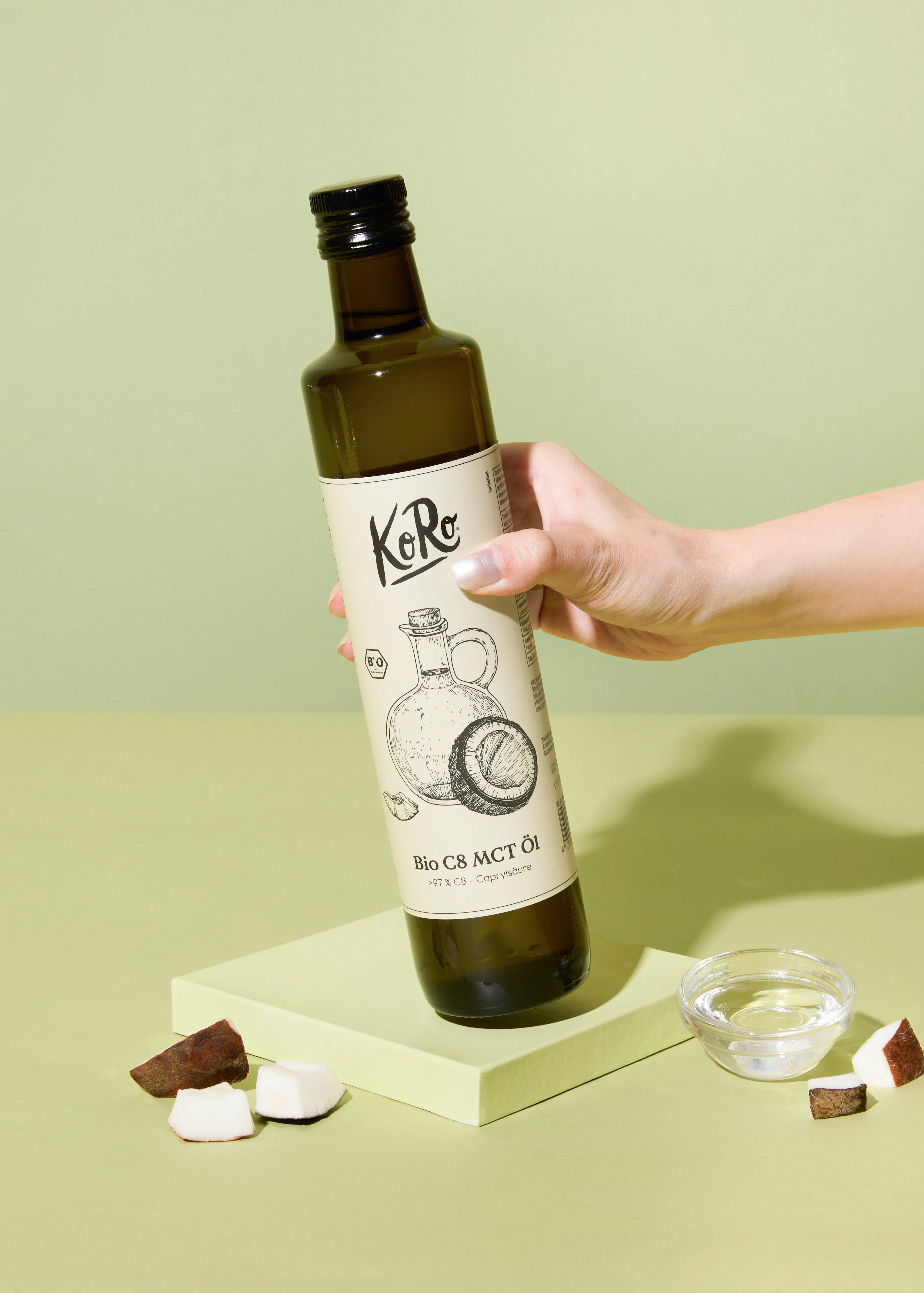 una persona sostiene una botella de aceite de coco bio c8 mct
