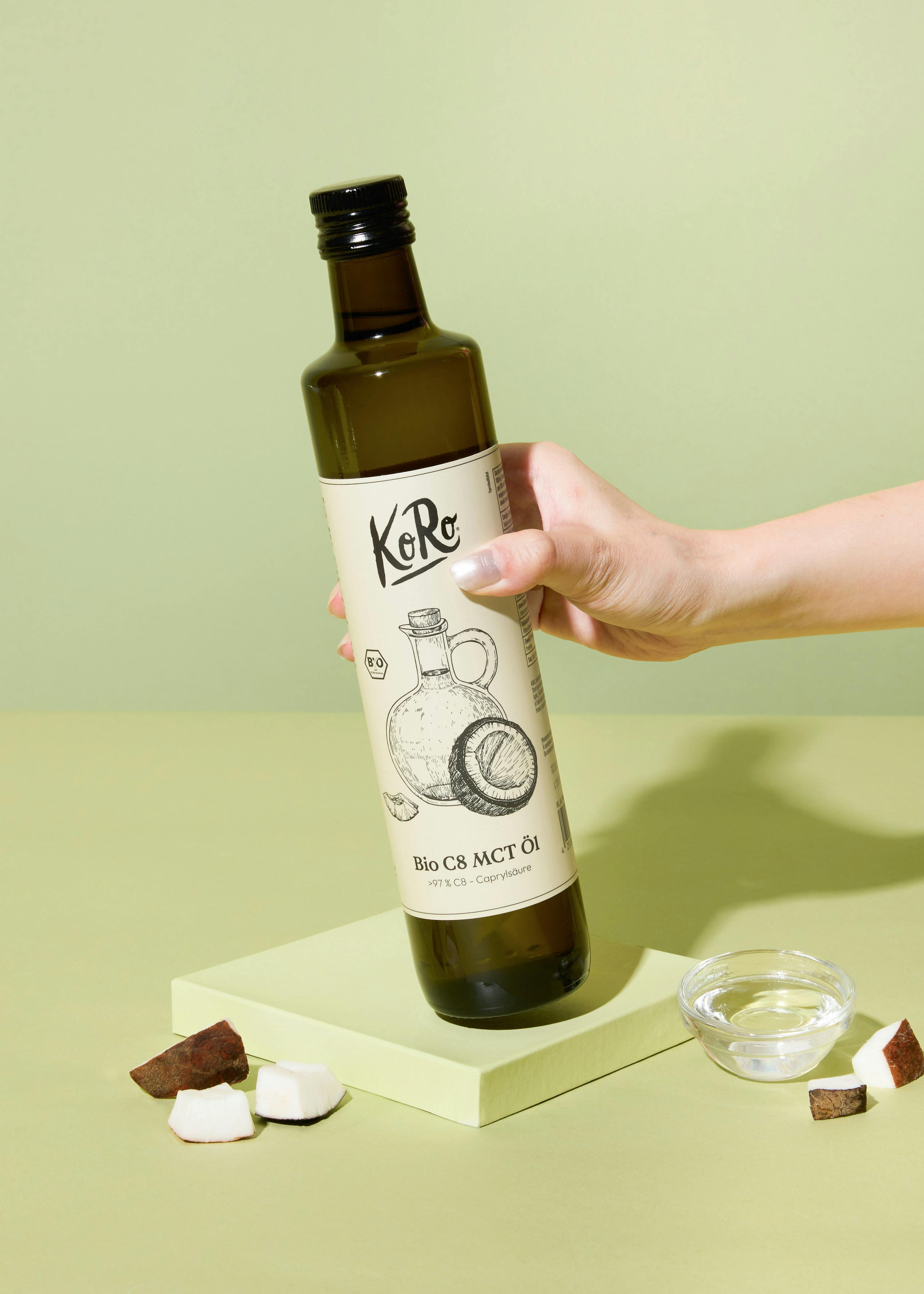 une personne tient une bouteille d' huile de coco bio mct