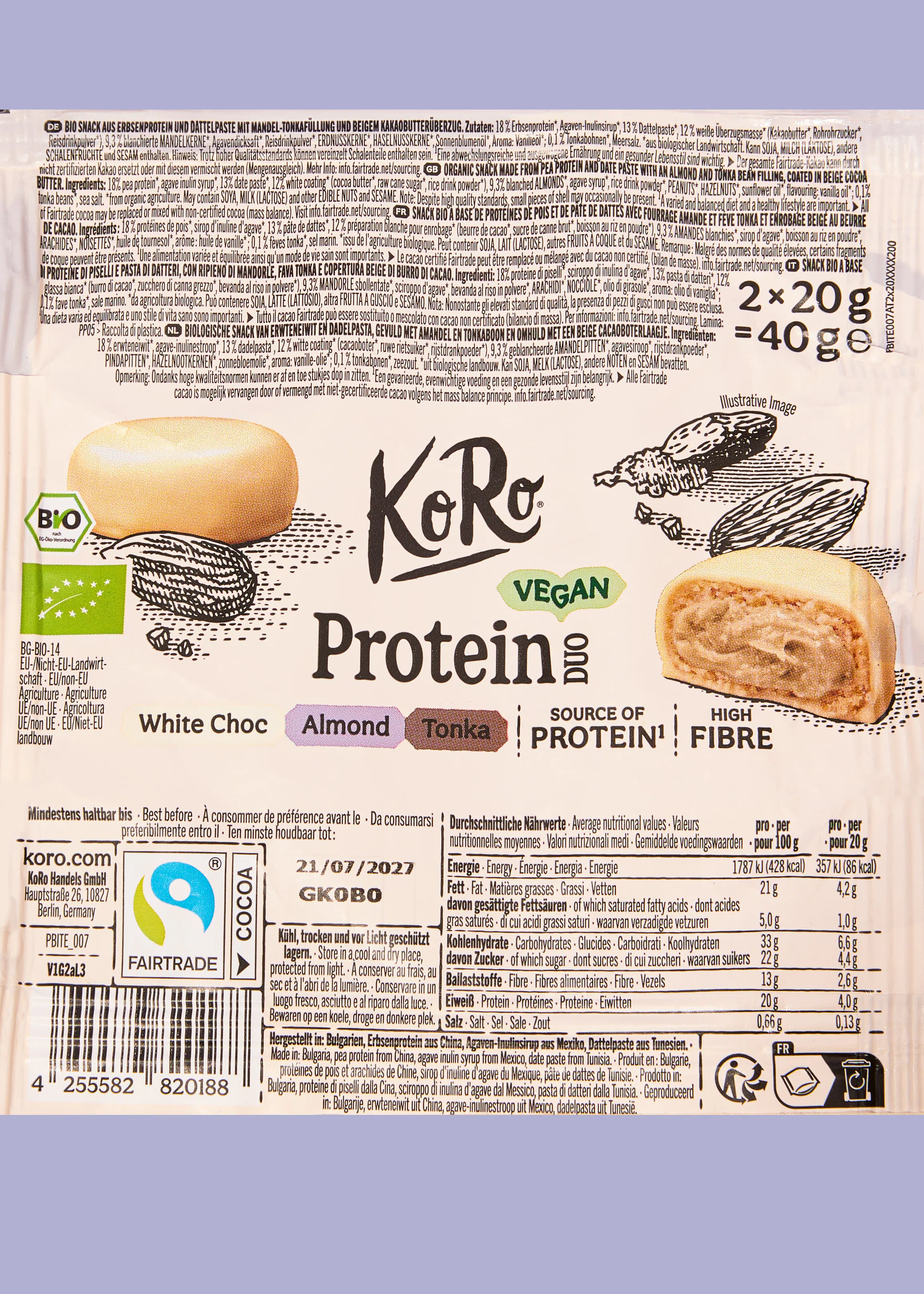die rückseite einer koro proteinriegel-verpackung mit mandel-tonka-geschmack, die zutaten, nährwertangaben und produktinformationen in mehreren sprachen zeigt.