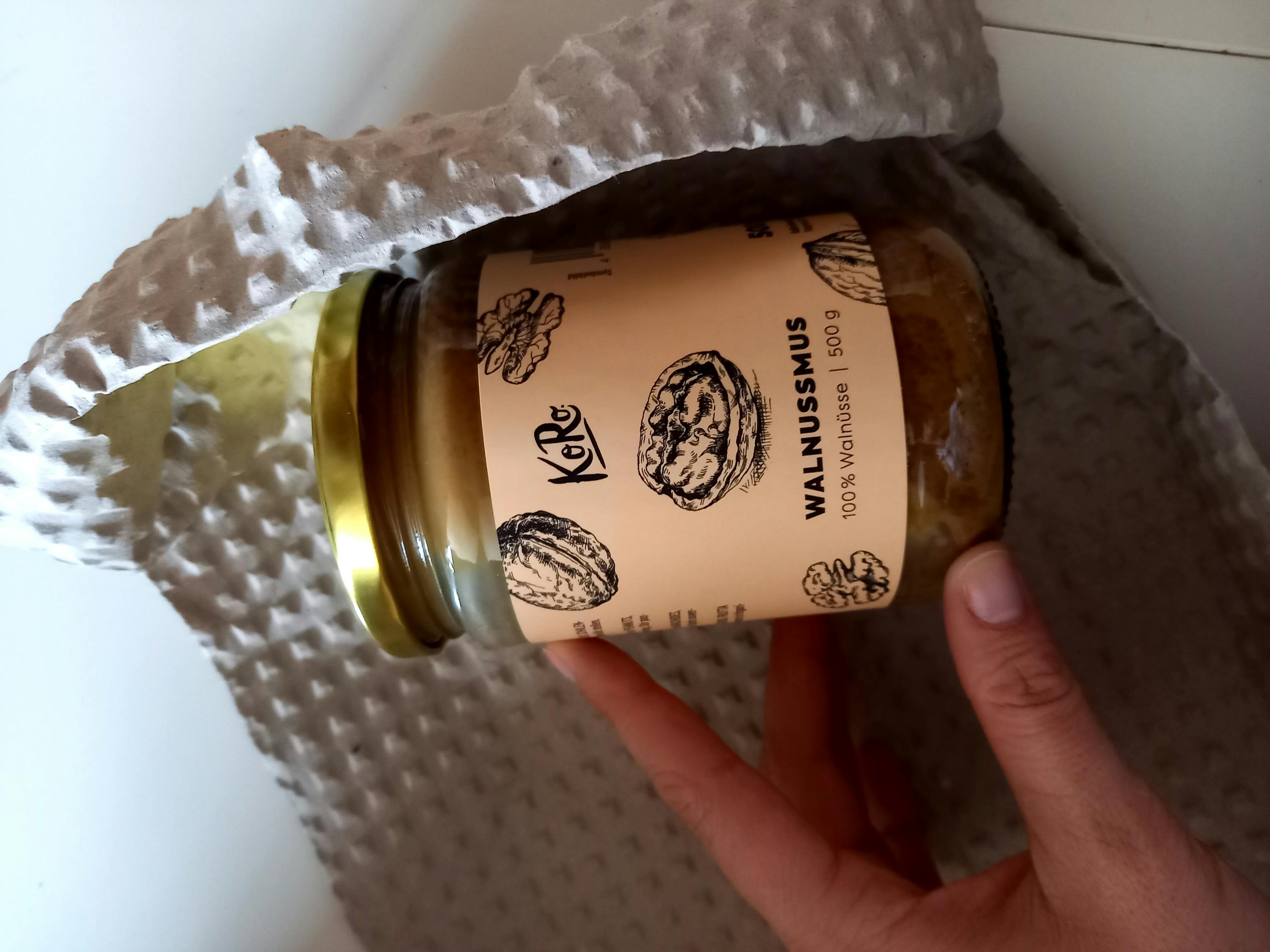 a person is holding a jar of walnussmus