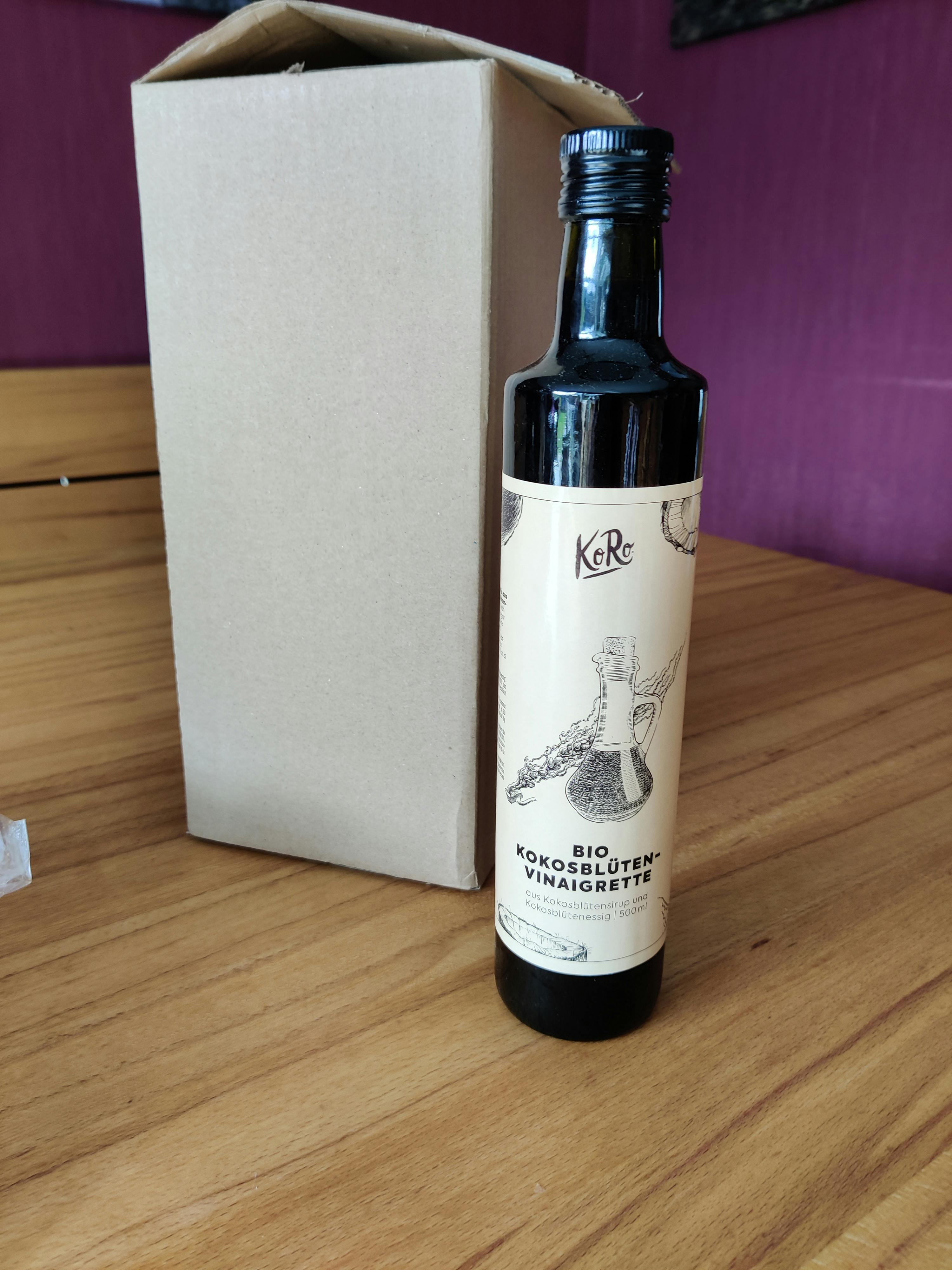 una bottiglia di olio è seduta su un tavolo accanto a una scatola di cartone