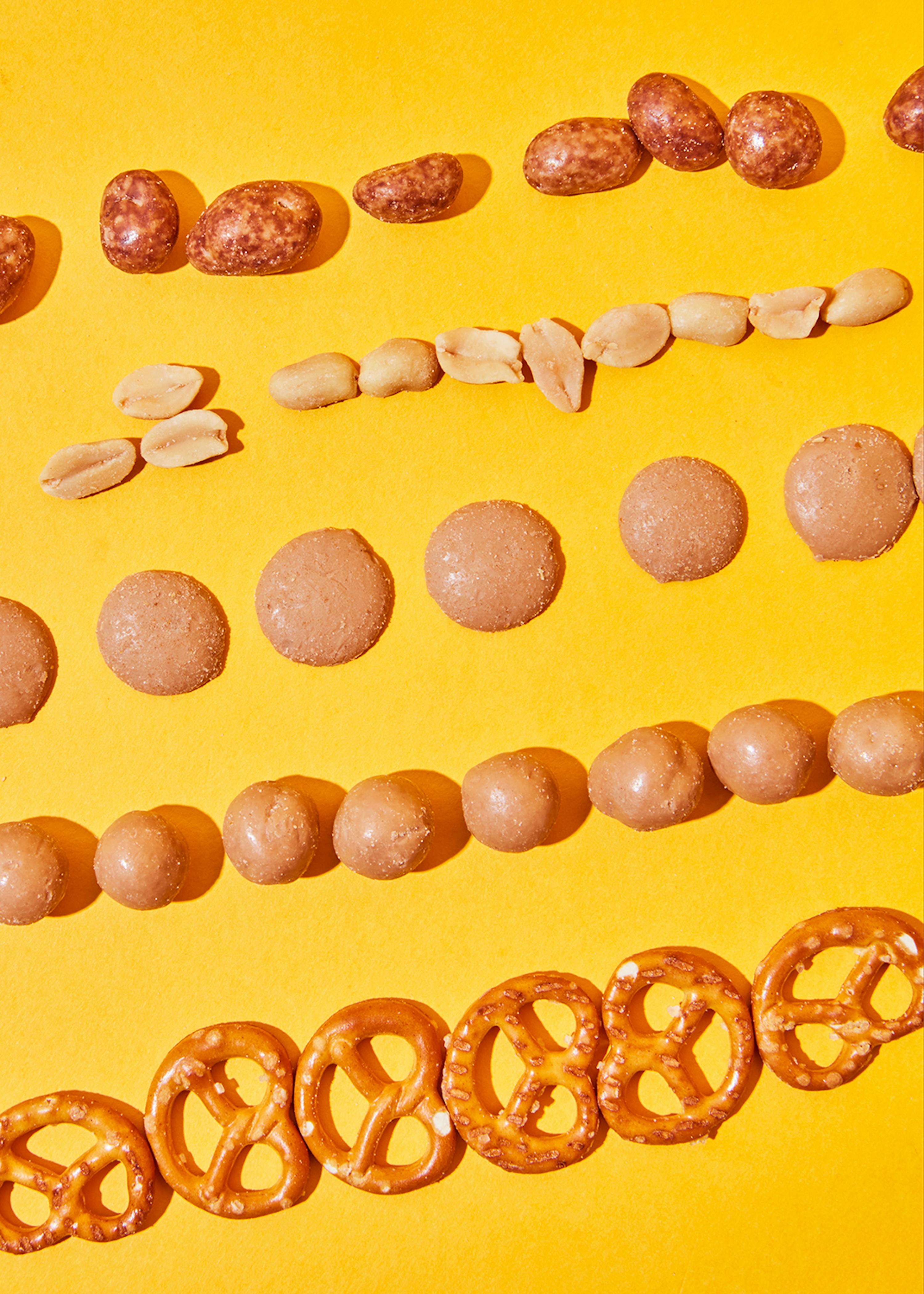 une rangée de bretzels et de cacahuètes sur un fond jaune
