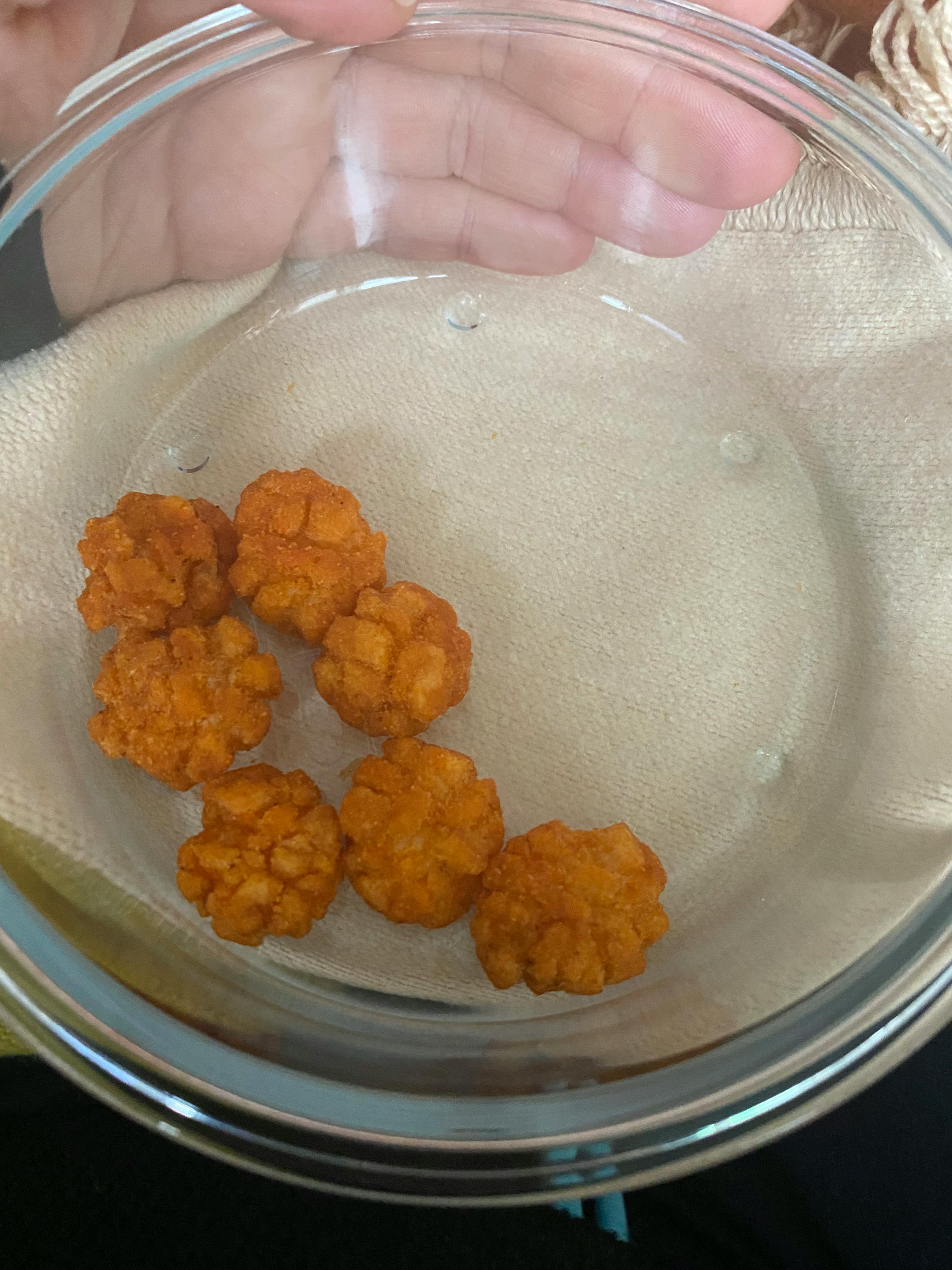 une personne tient un bol en verre rempli de nourriture