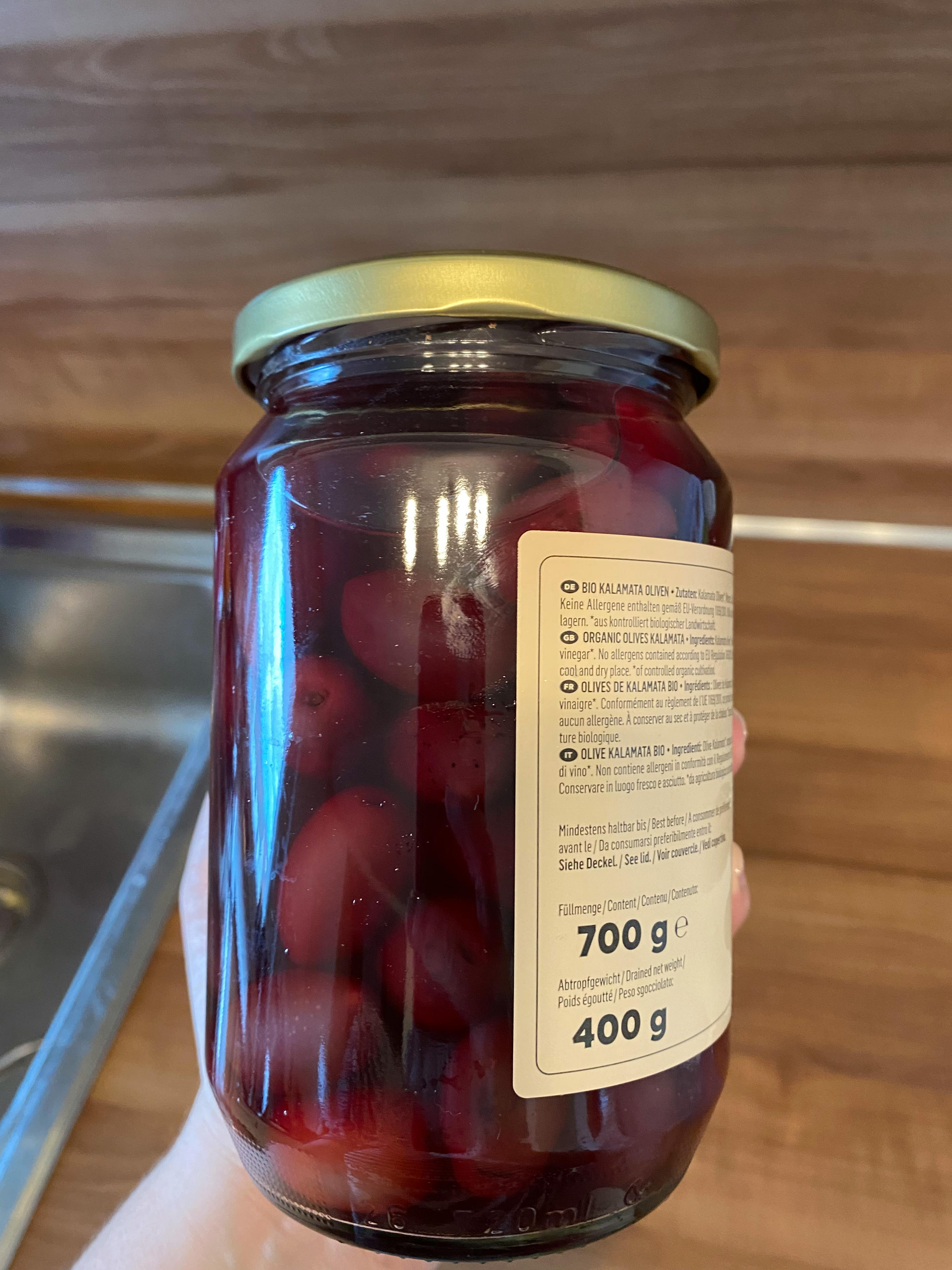 eine Person hält ein Glas gefüllt mit Kirschen mit einem Gewicht von 700 g